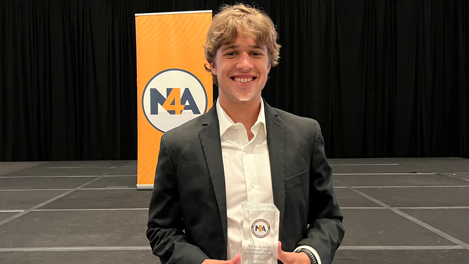Owen Pukys holds up the Wilma Rudolph Award At NACDA