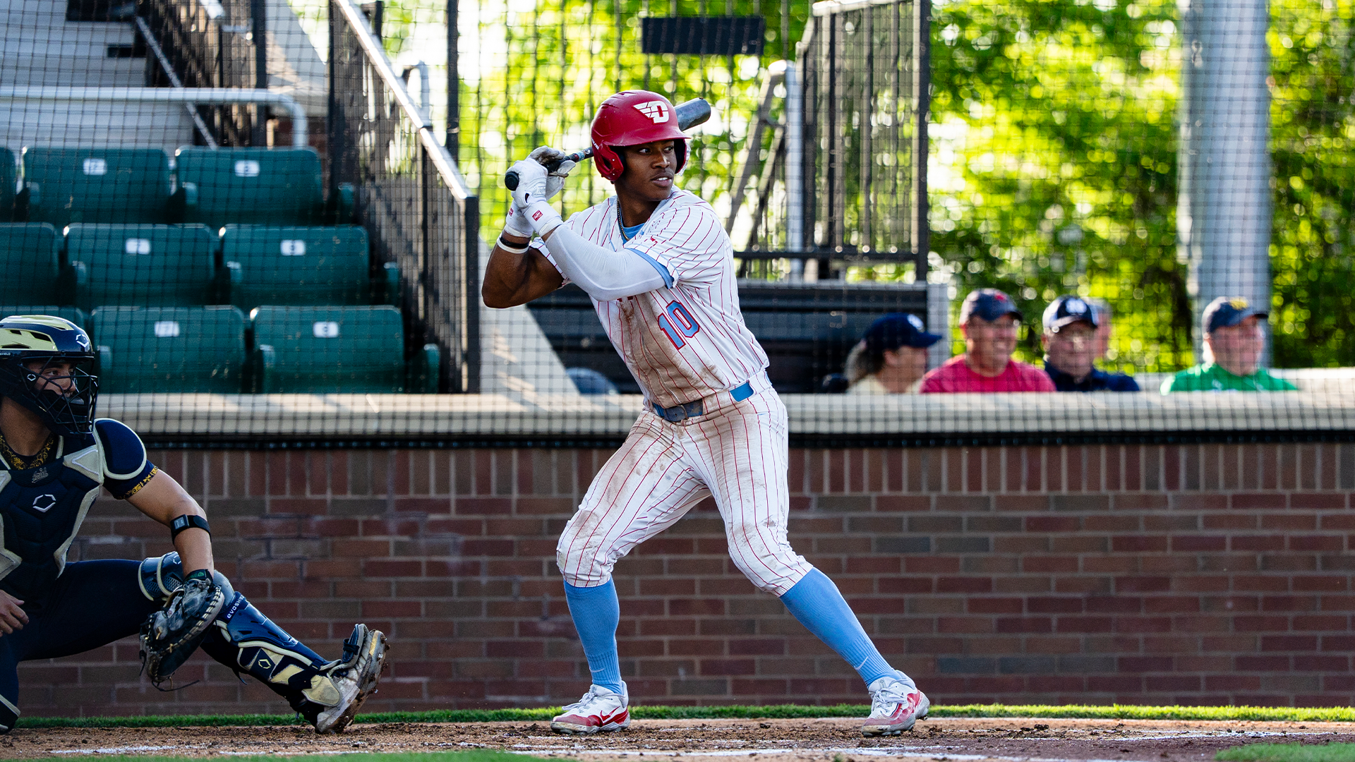 Michael Smith Jr. stands in the right-handed batter's box, waiting for the pitch. He is wearing a white pinstripe uniform and a red helmet.