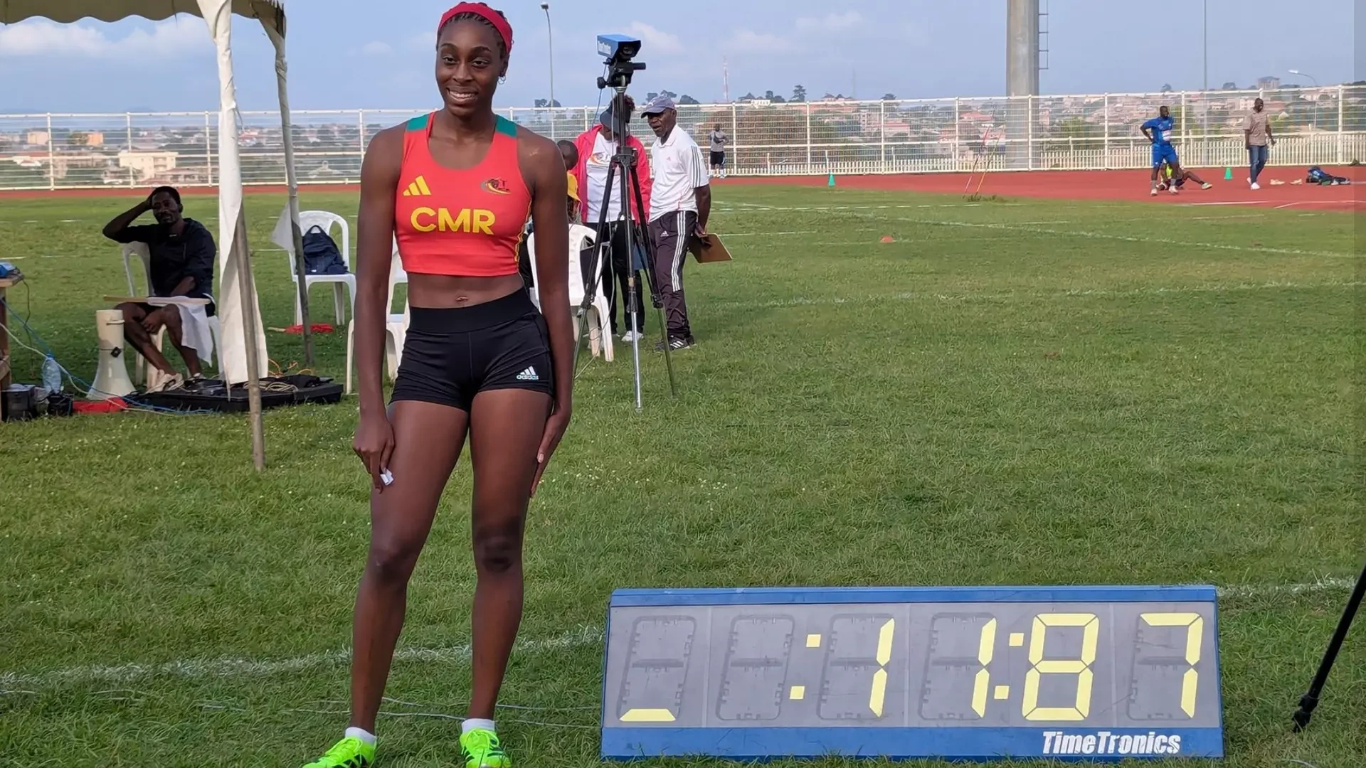 Simone Bessong stands next to her winning time of 11.87 in the 100m at the Cameroon National Championships