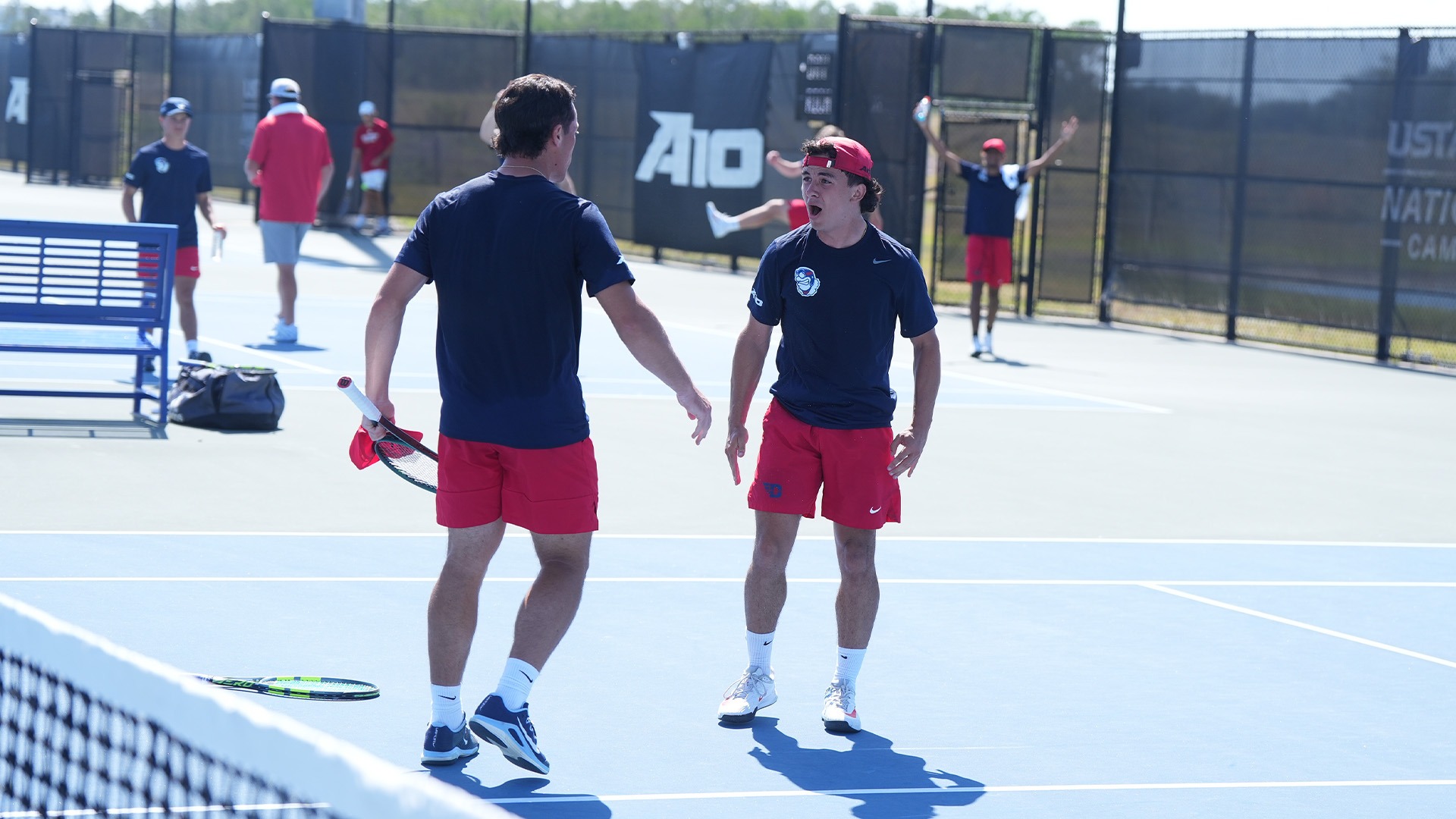 Mikkel Zinder and Dylan Jaen high-five in celebration after winning their doubles match.