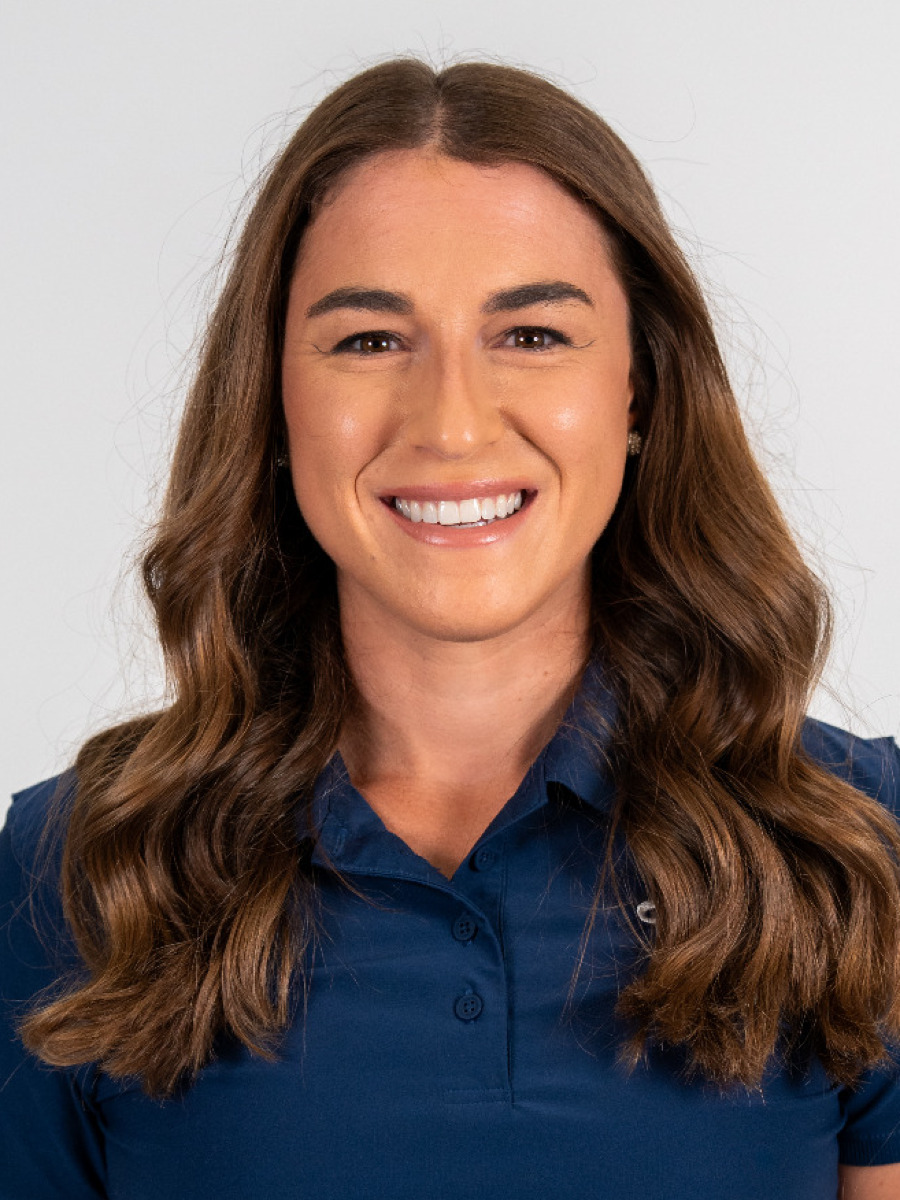 Portrait image of women's golf head coach Ellie Sipe wearing a blue polo-style shirt