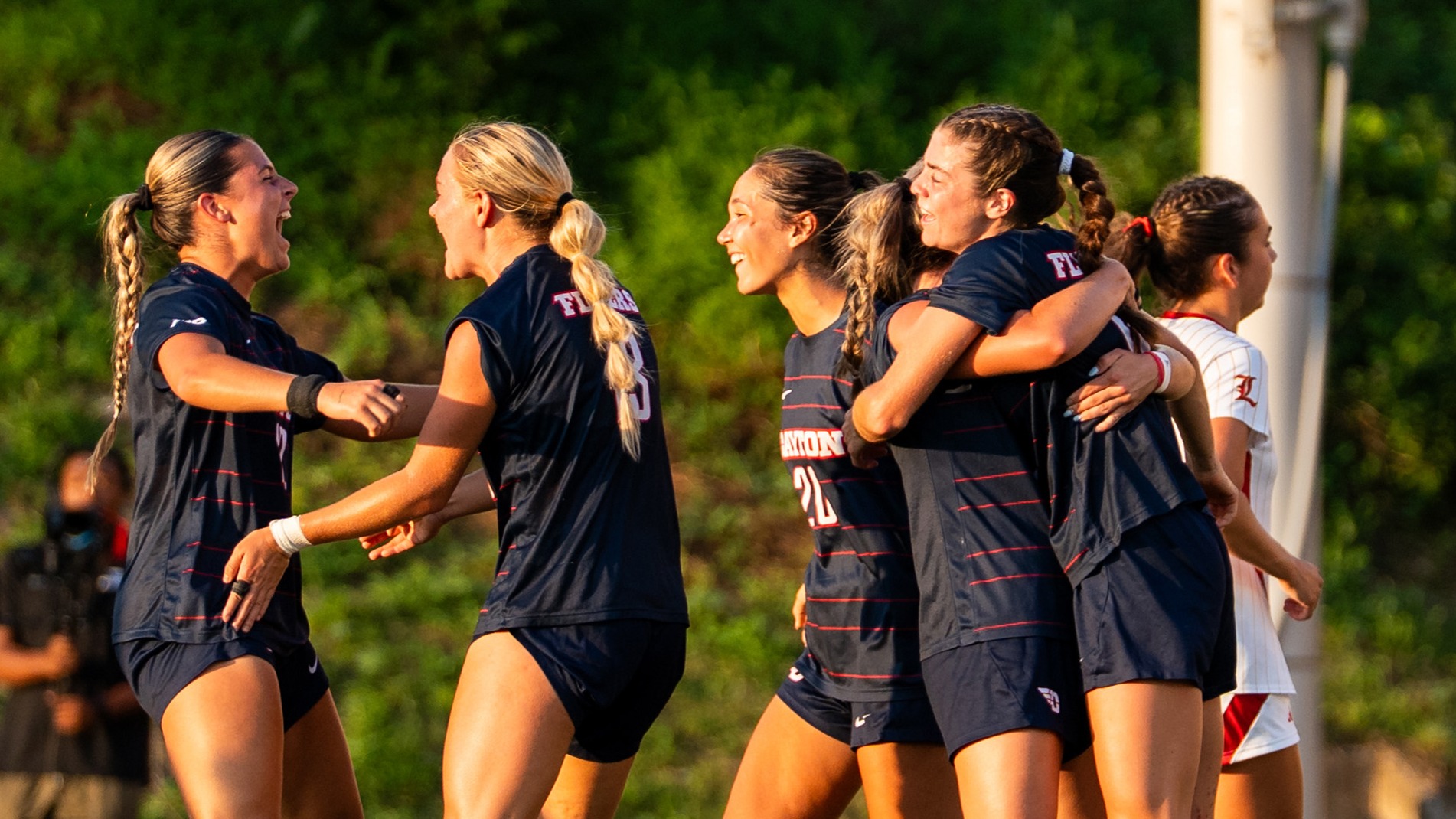 Dayton Women's soccer players celebrate scoring a goal against Louisville 