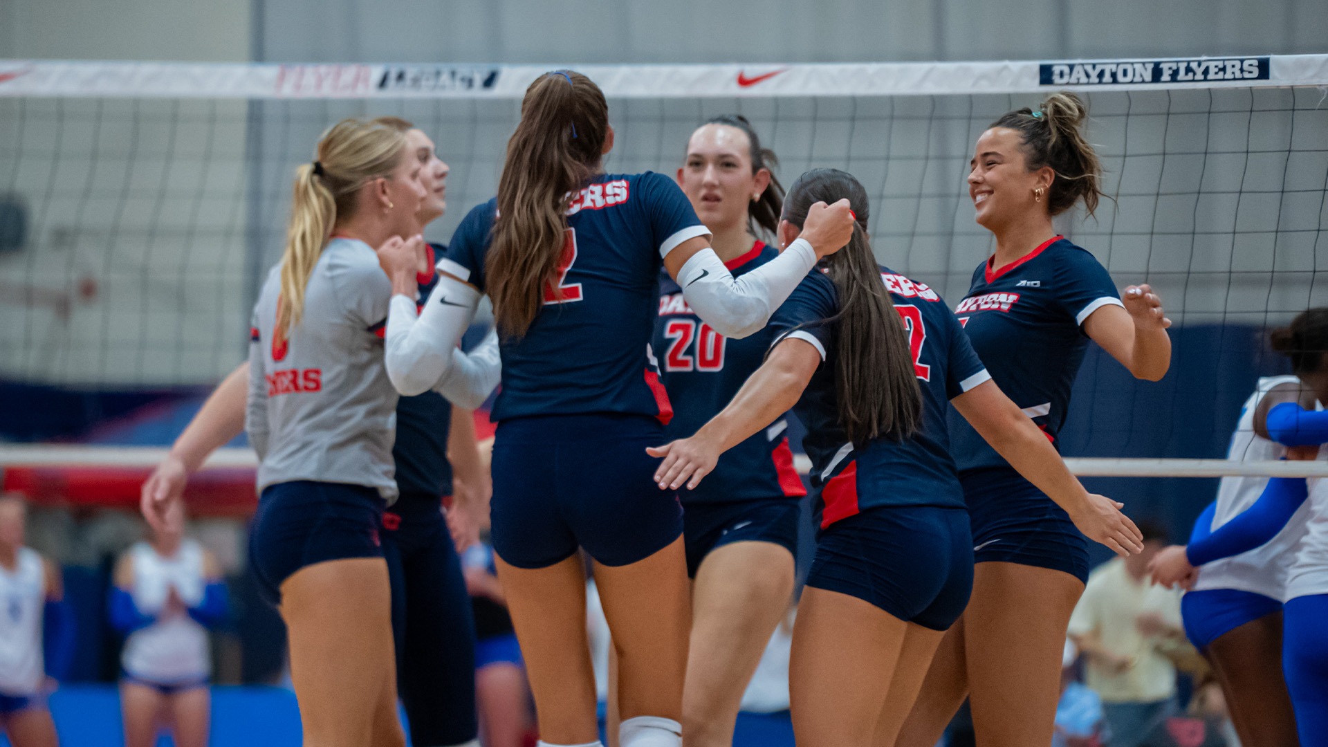 Players in navy uniforms celebrate after a point.