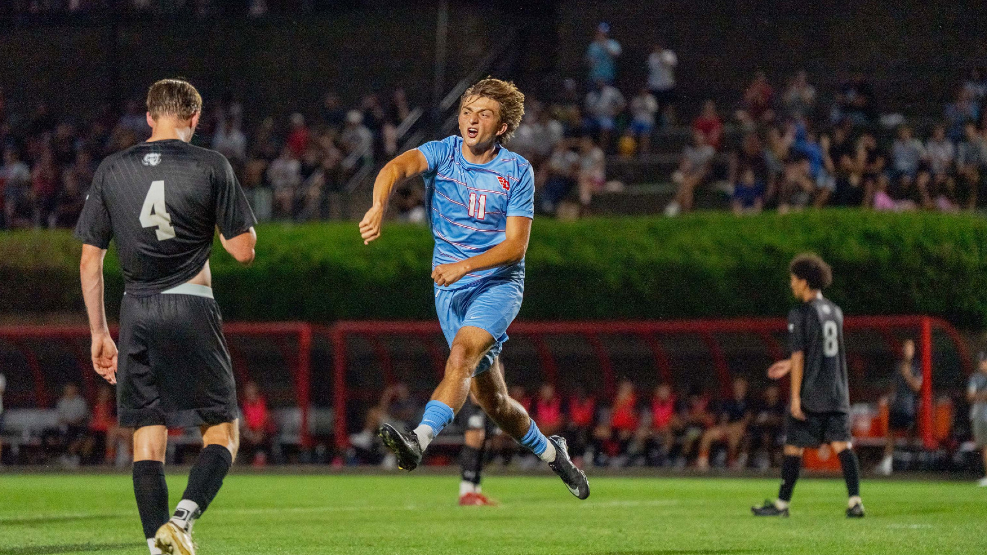 Men's soccer player number 11 Antonio Pinto, wearing a chapel blue kit, celebrates after scoring a goal against Purdue Fort Wayne at Baujan Field