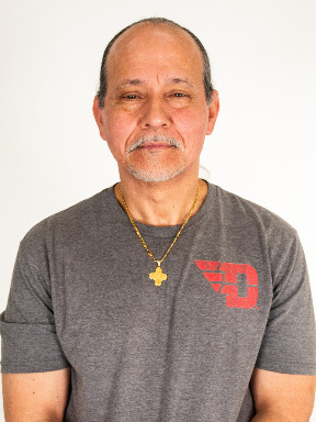 Portrait Image of Lou DeNeen wearing a gray tshirt with a red flying D logo