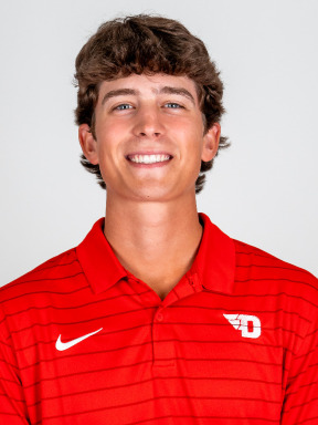 Portrait image of men's golfer Victor Caliguri wearing a red polo-style shirt with a white Nike logo and flying D logo
