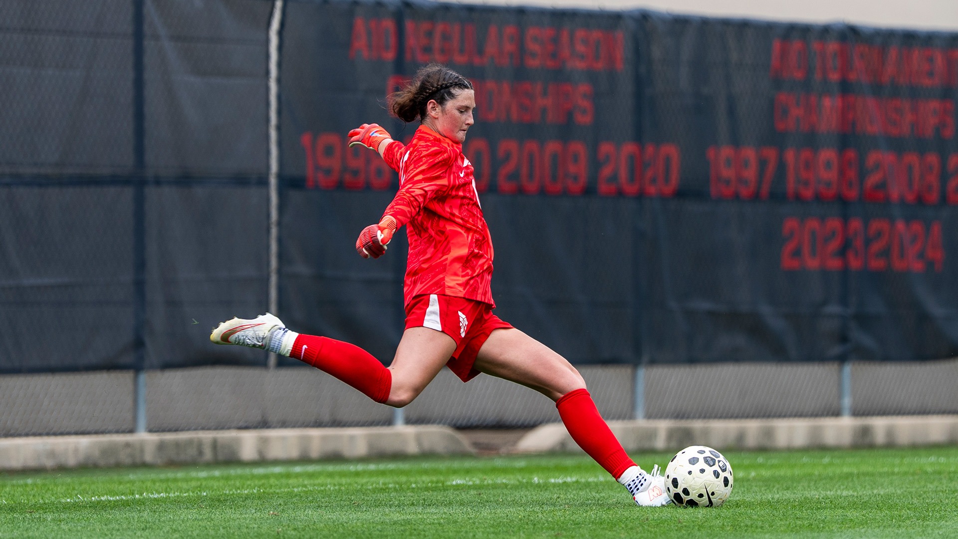 Dayton women's soccer player Kasey Cannistraro, wearing the red goalie jersey, takes a goal kick.