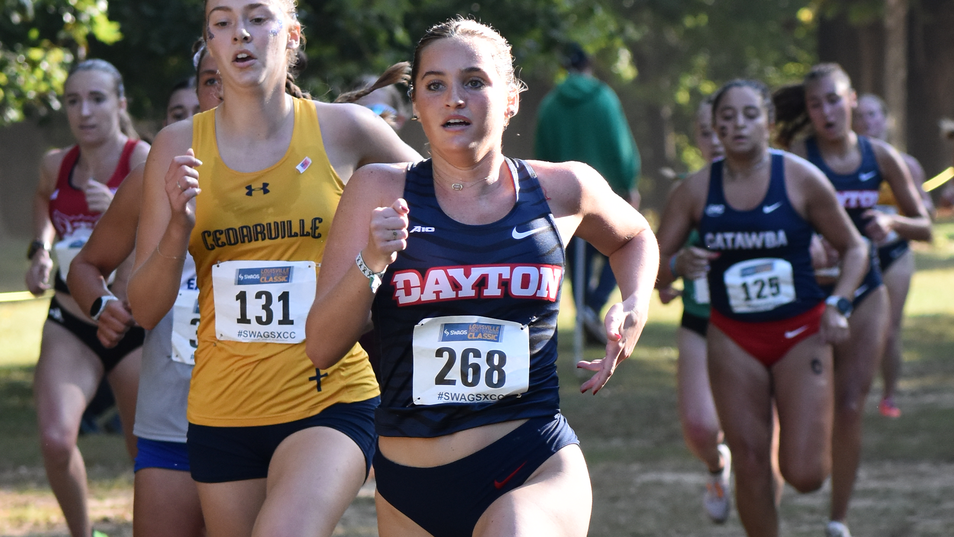 Anna Newkirk Crossing the Finish Line in a Navy Blue Dayton Jersey 