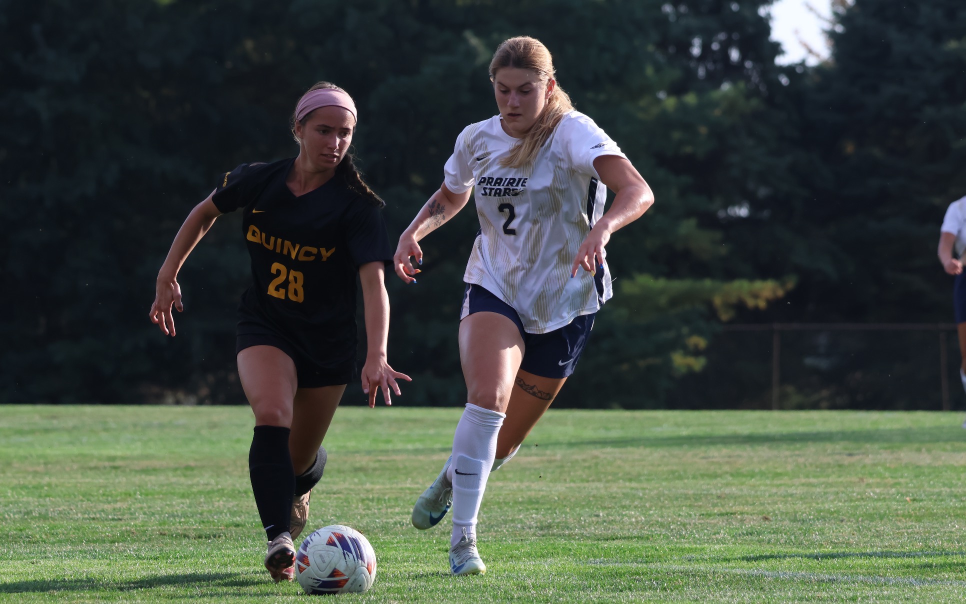 Kalli Drexler playing soccer in white UIS uniform