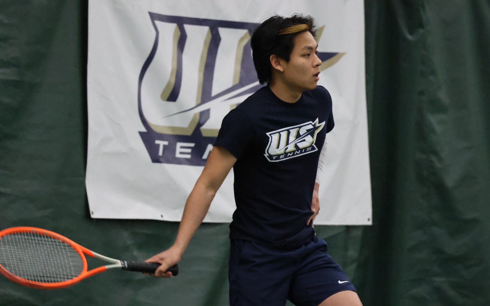 LIN EN TAN PLAYING TENNIS, FEATURING UIS TENNIS BANNER