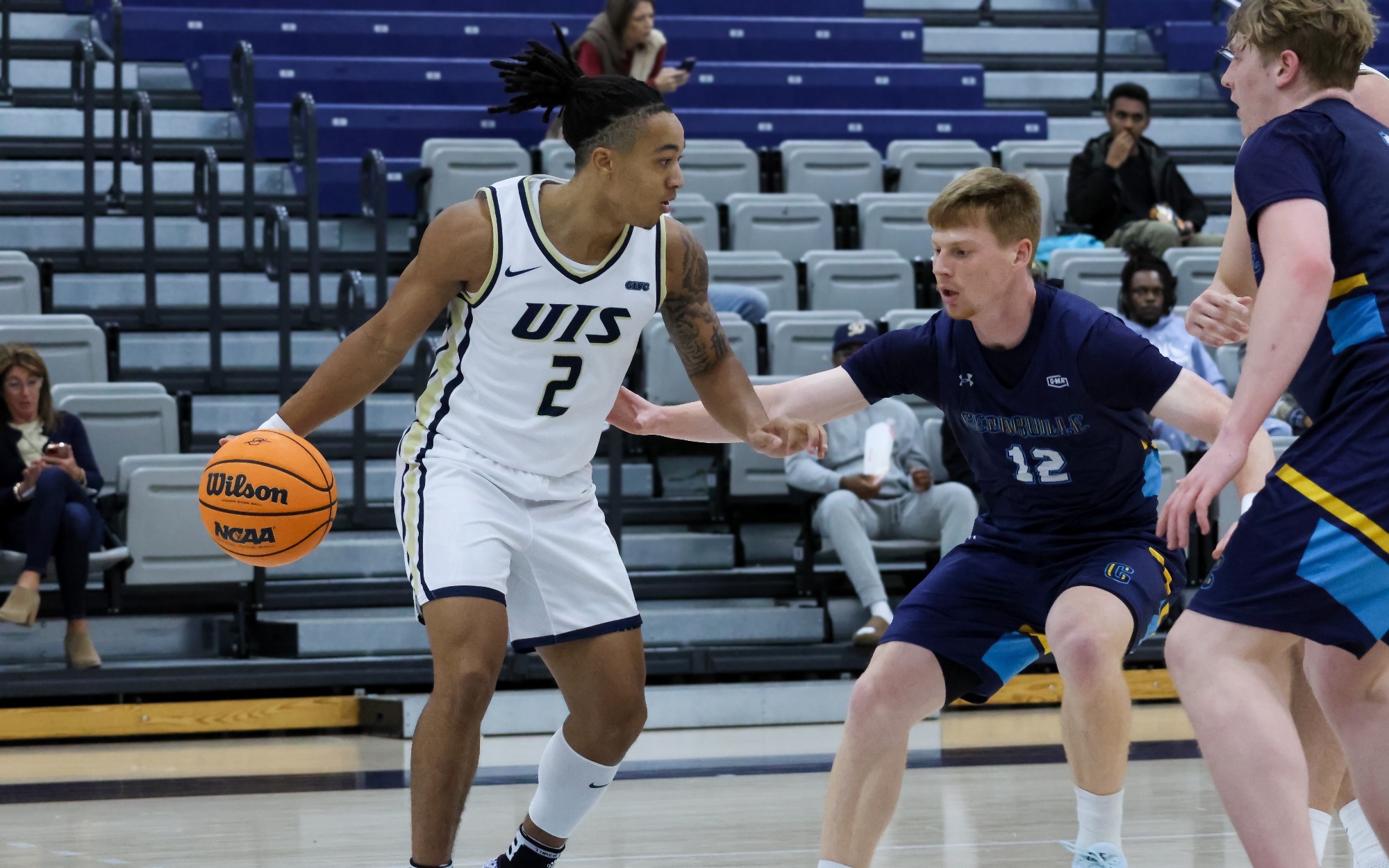 Jordan Rice playing basketball in white UIS uniform