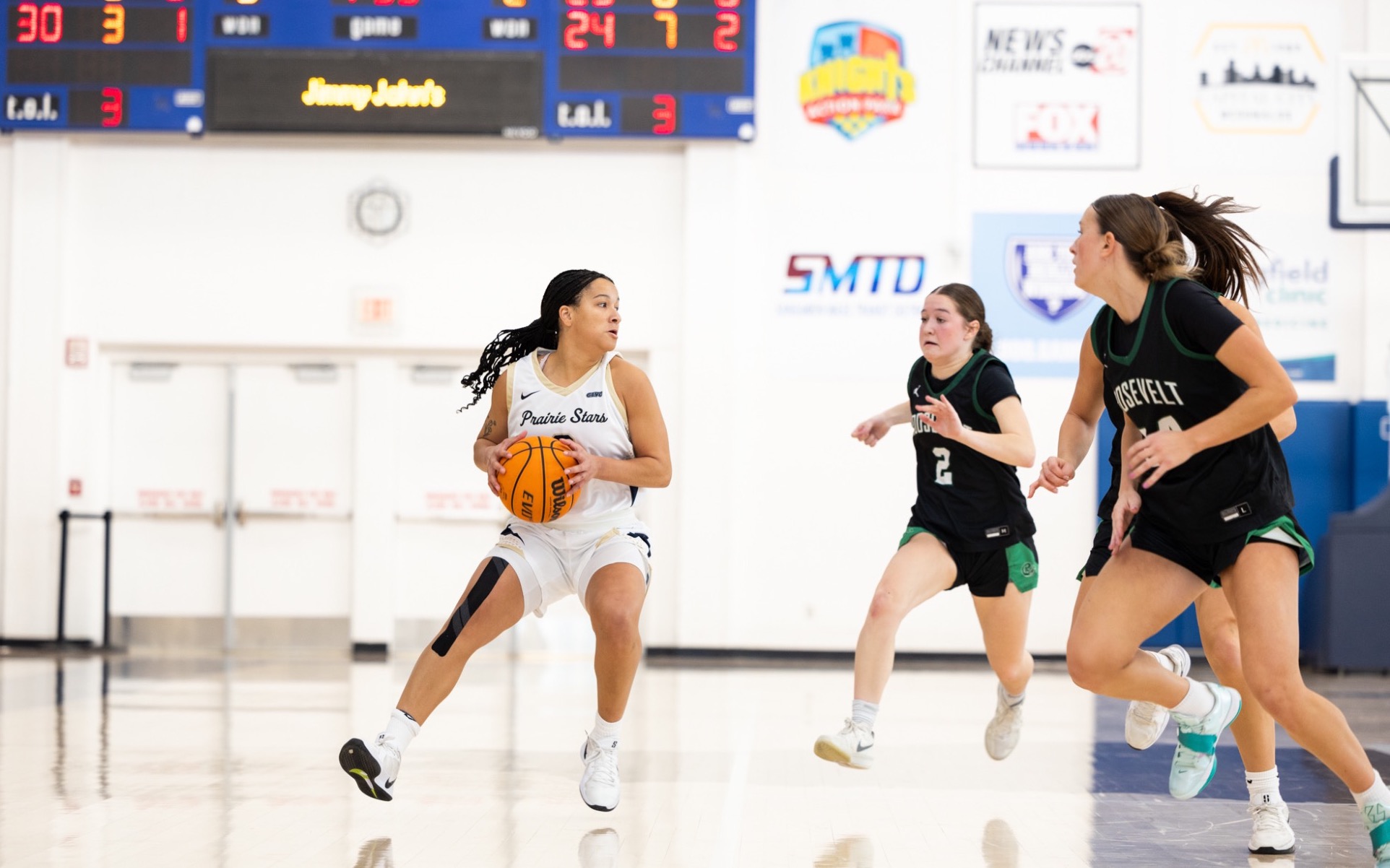 Kayla Rice playing basketball in white UIS uniform