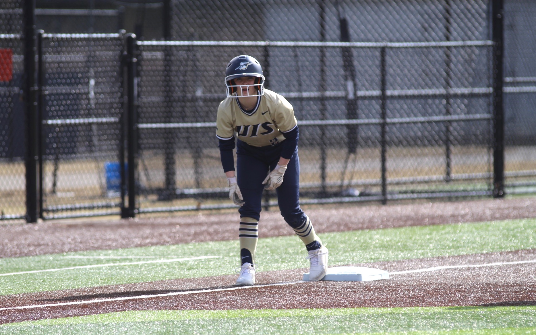 Rebecca Neupauer base running in gold UIS uniform