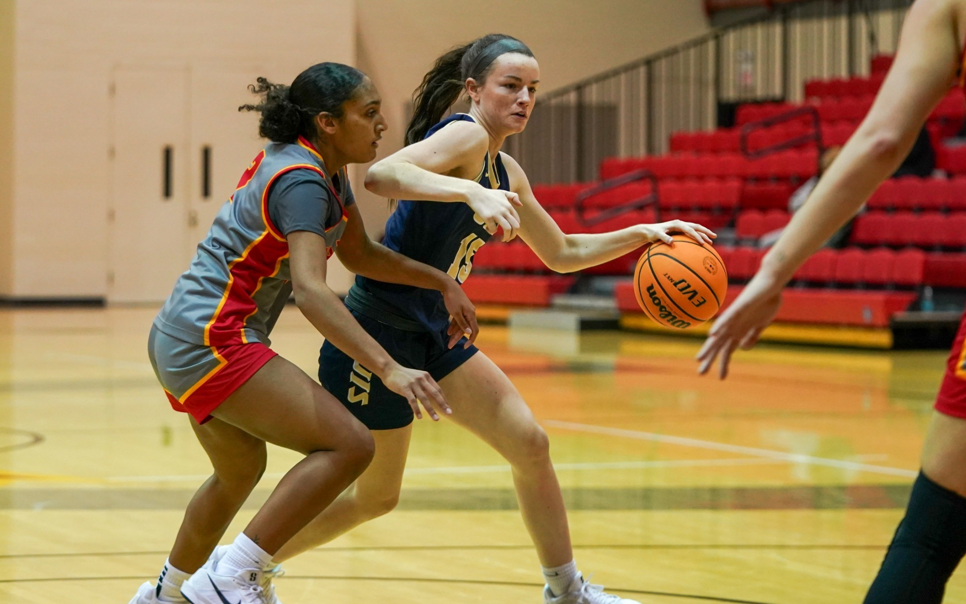 Molly Knight playing basketball in blue UIS uniform