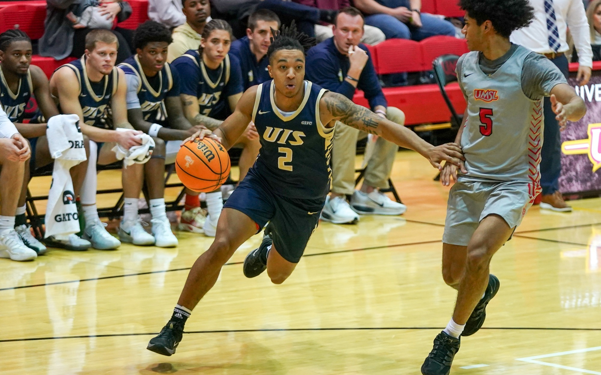Jordan Rice playing basketball in blue UIS uniform