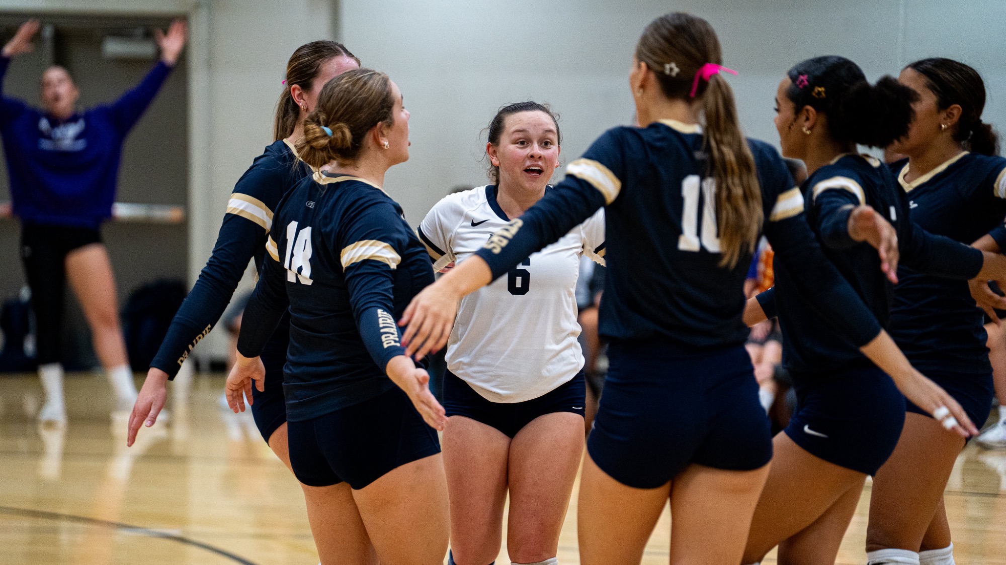 UIS Volleyball team huddle on the court