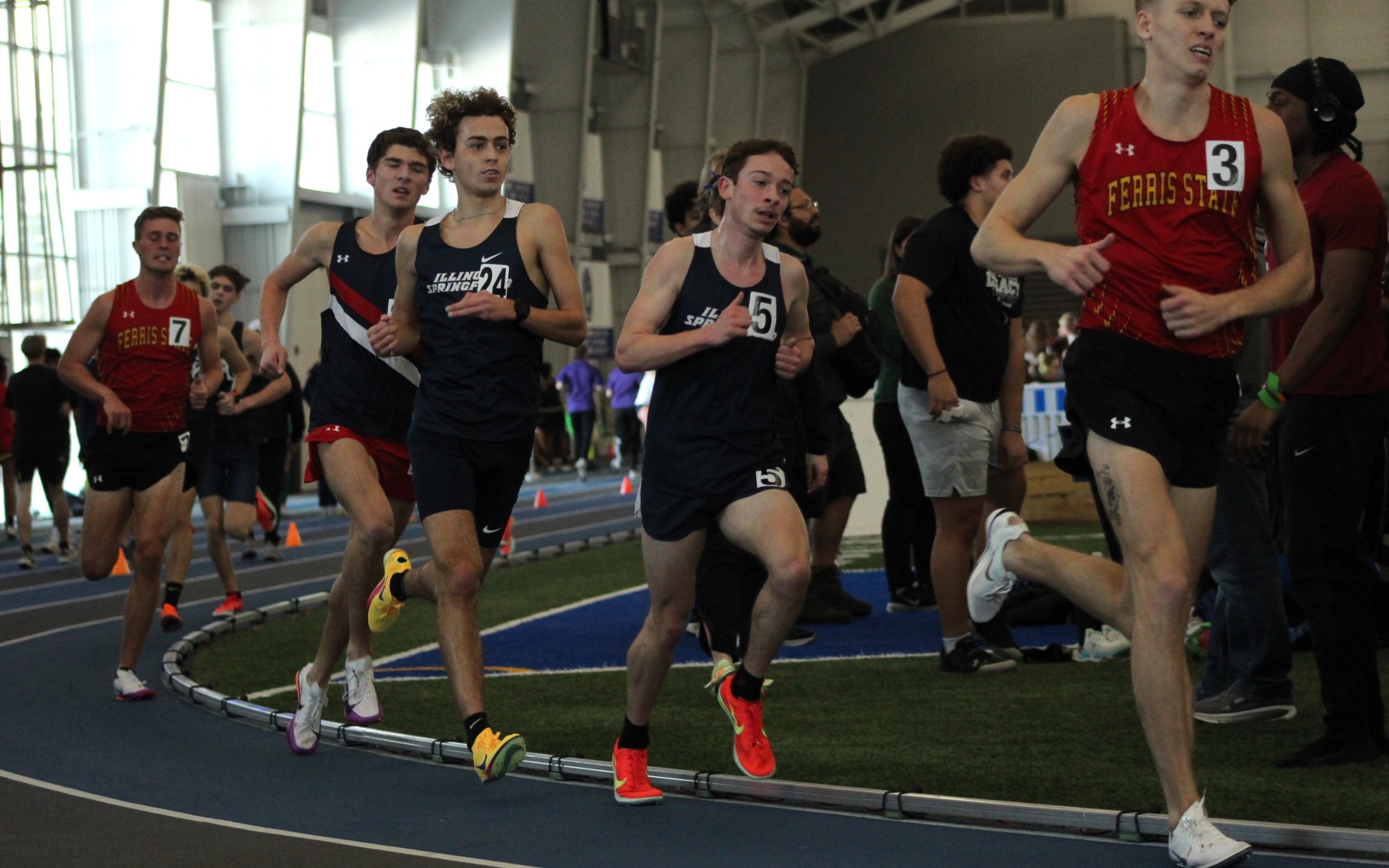 UIS men's track athletes running an indoor race