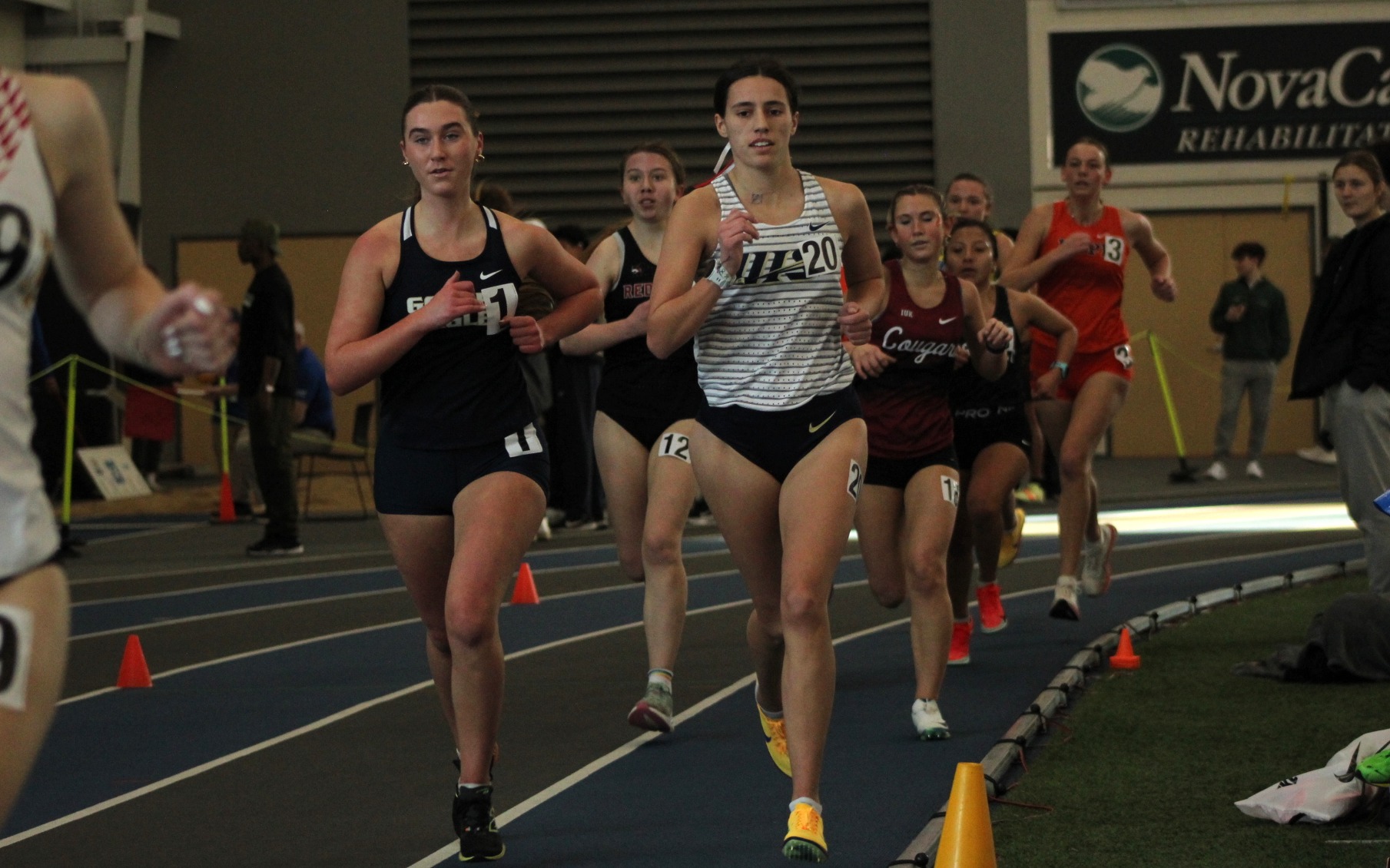 Mackenzie Billard running indoor track in white UIS uniform