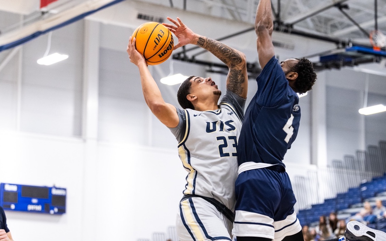 Tye Banks playing basketball in gray UIS uniform