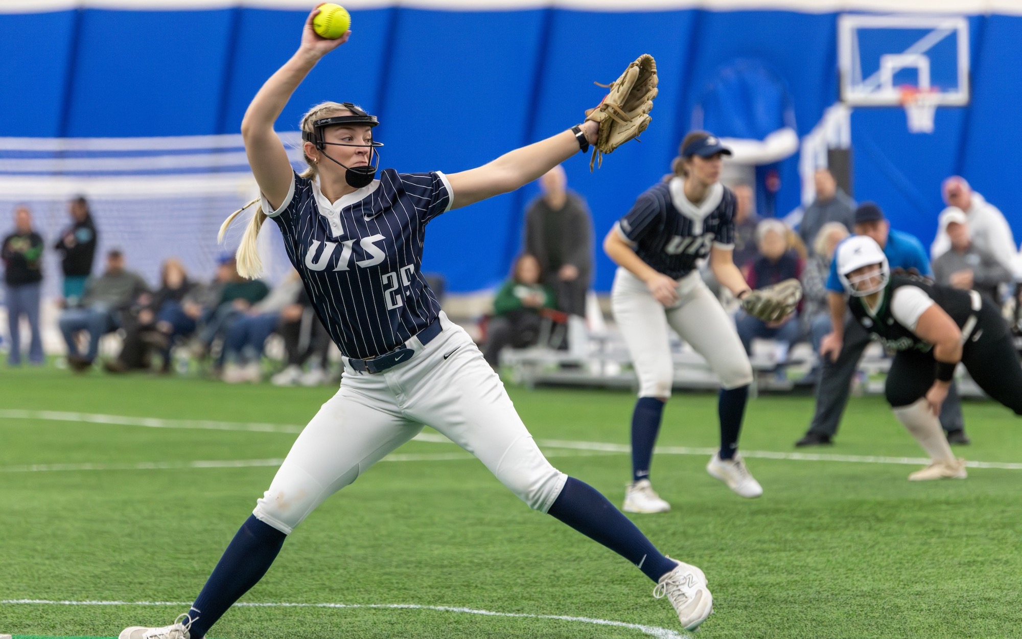 Calista Stahlhut pitching in blue UIS softball uniform