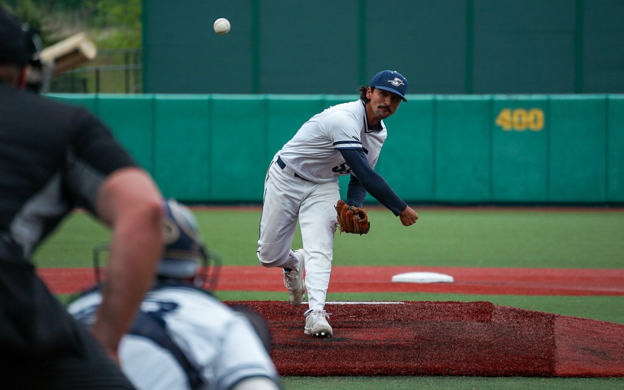 Esteban Hernandez pitching in white UIS uniform