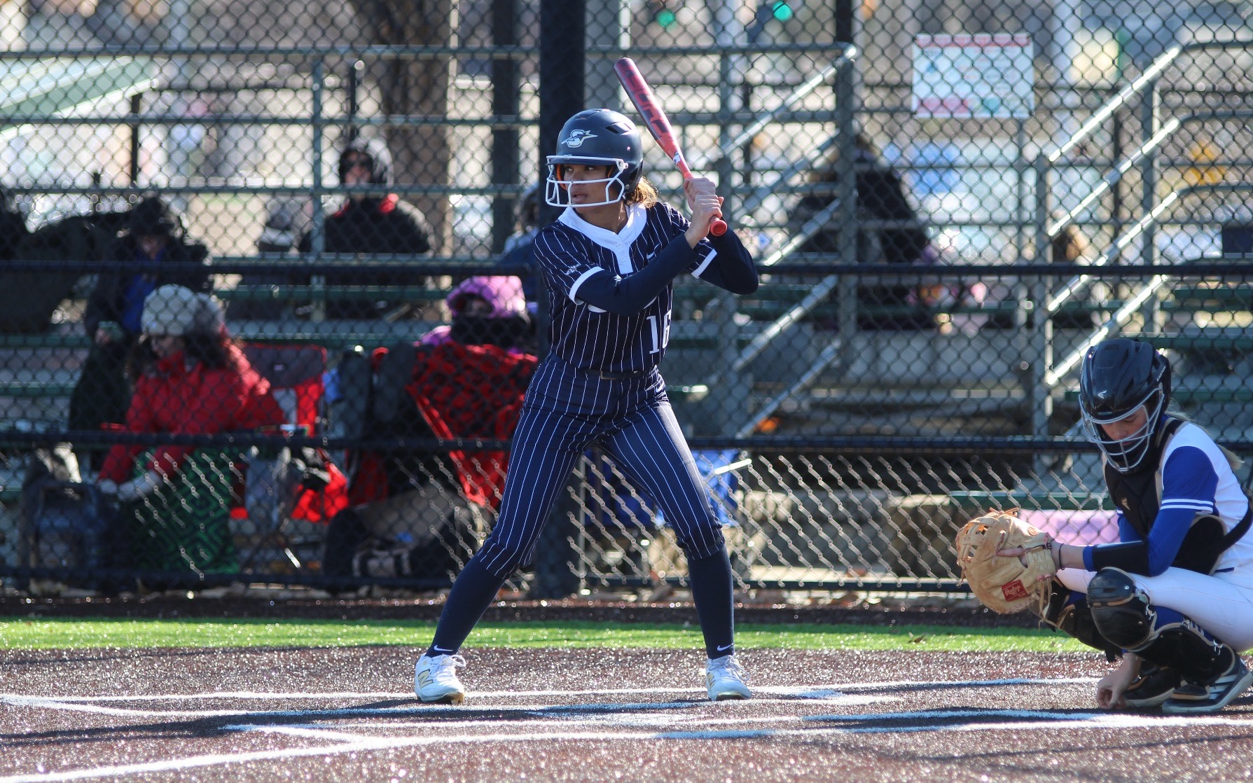 Sidney Sawyer playing softball in blue UIS uniform