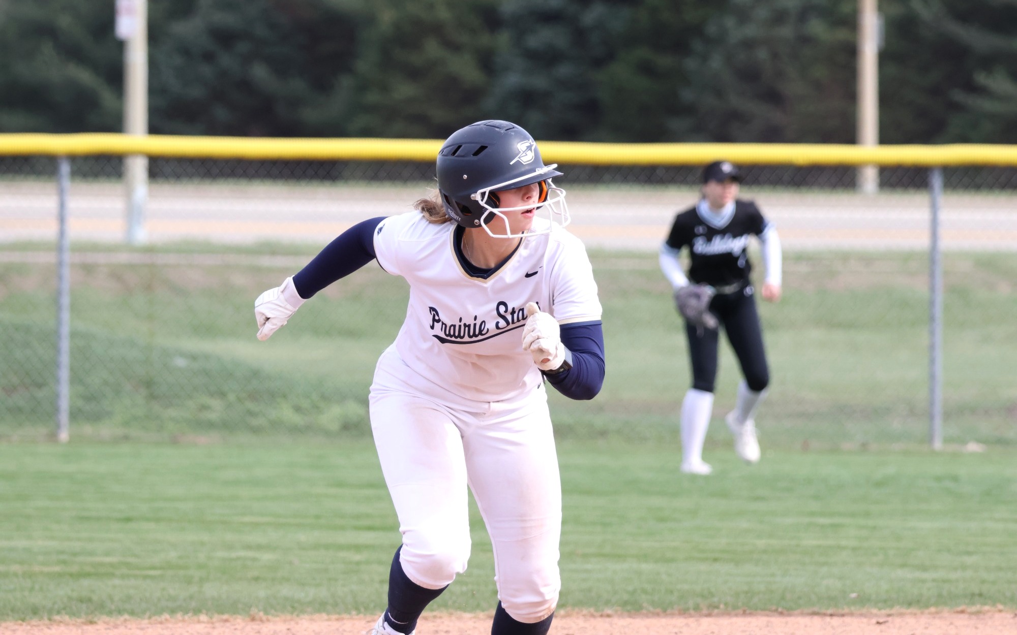 Rachel McMullen running the bases in white UIS softball uniform