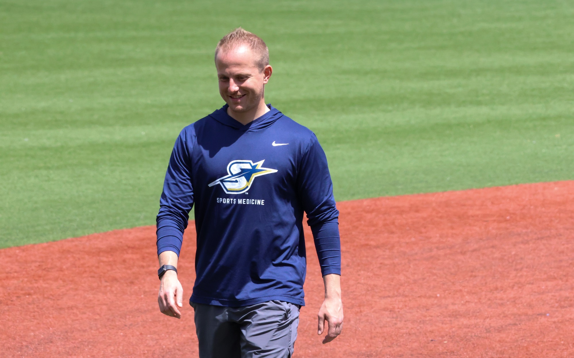 UIS Athletic Trainer Ryan Margold walking across baseball field