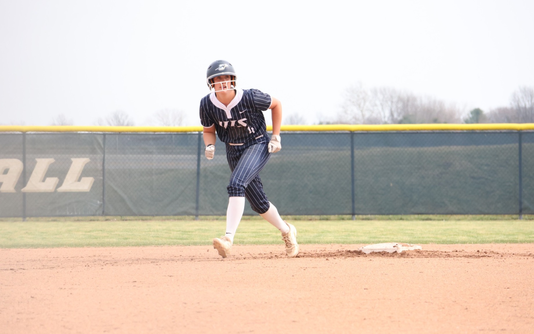 Bailey Masching baserunning in blue UIS softball uniform