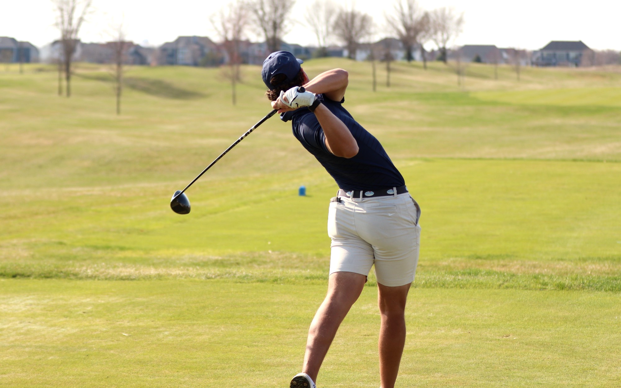 Julien Babineau playing golf in blue UIS polo