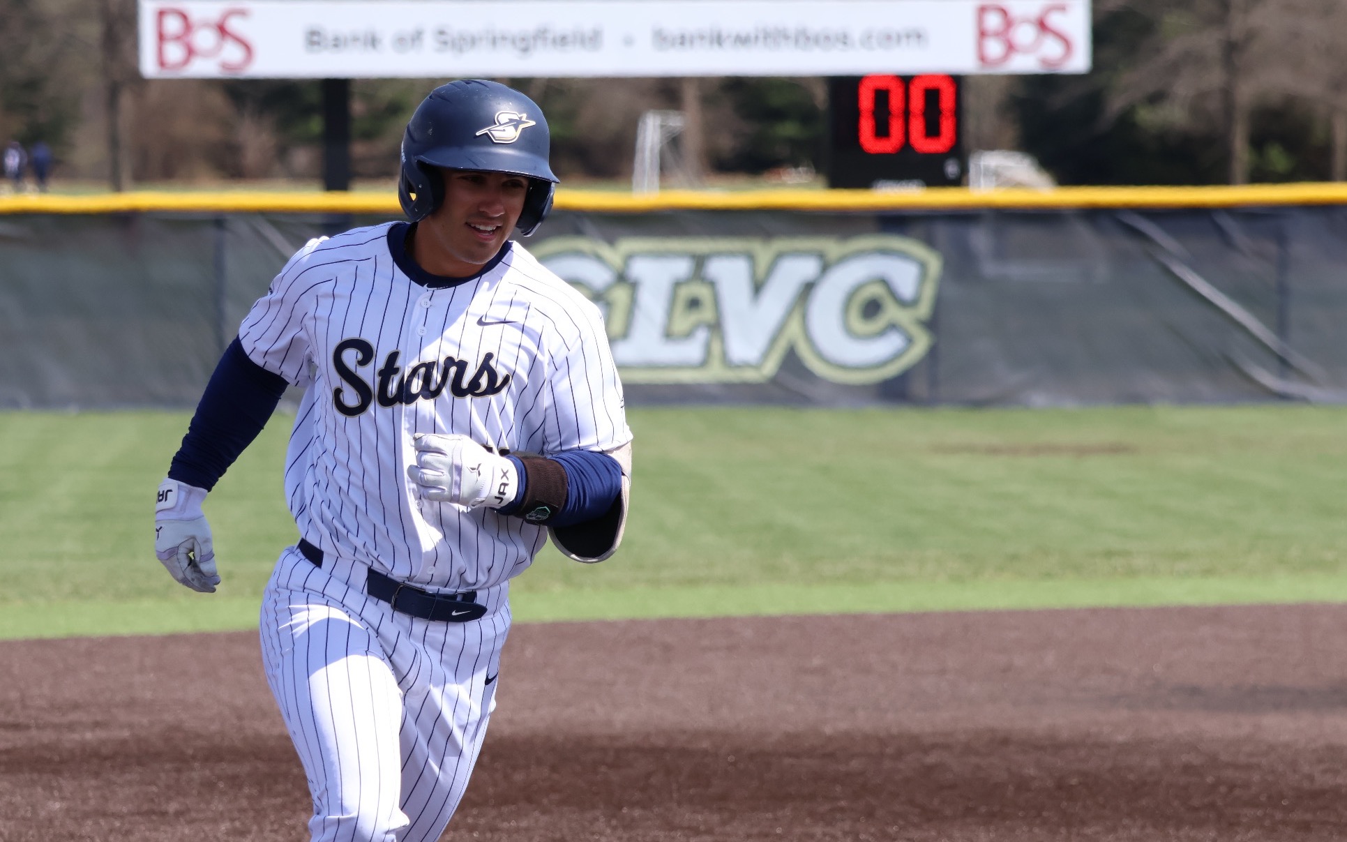 Tommy Atkinson rounding third  in white UIS baseball uniform