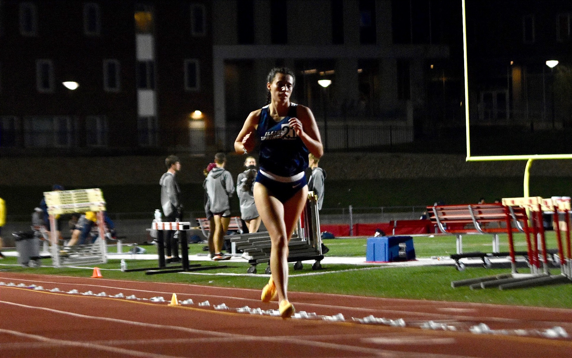 Mackenzie Billard running outdoor track in the evening in blue UIS uniform