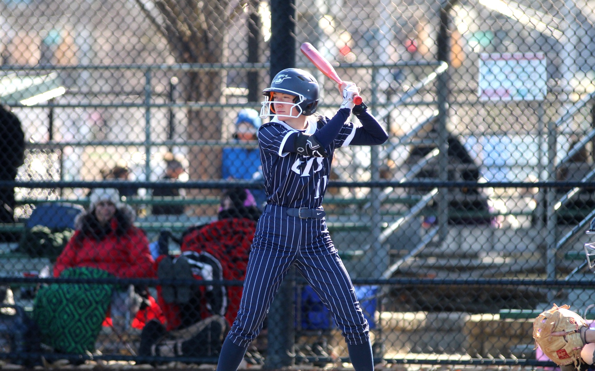 Chloe Scroggins playing softball in blue UIS uniform