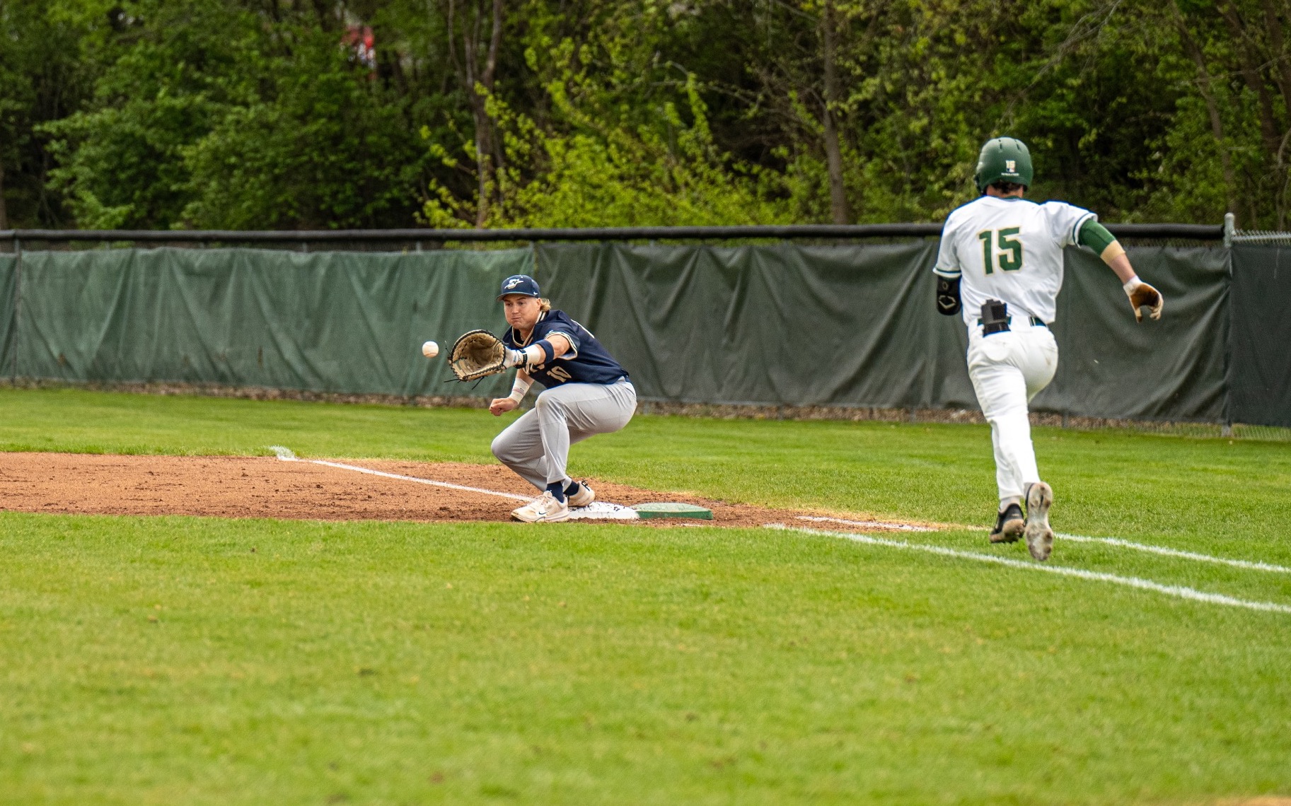 Drew Ezard playing first base in blue UIS baseball uniform