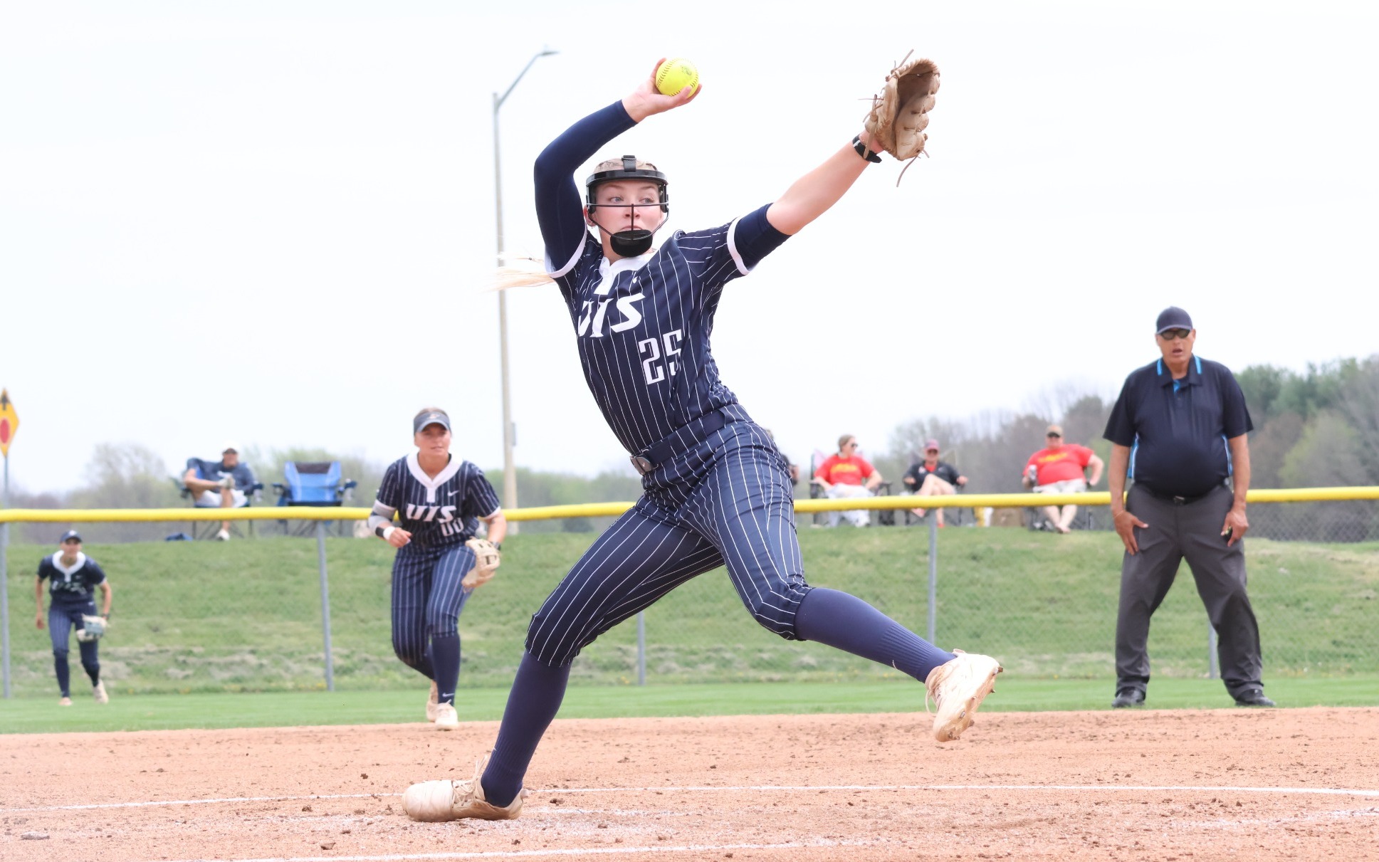Calista Stahlhut pitching in blue UIS softball uniform