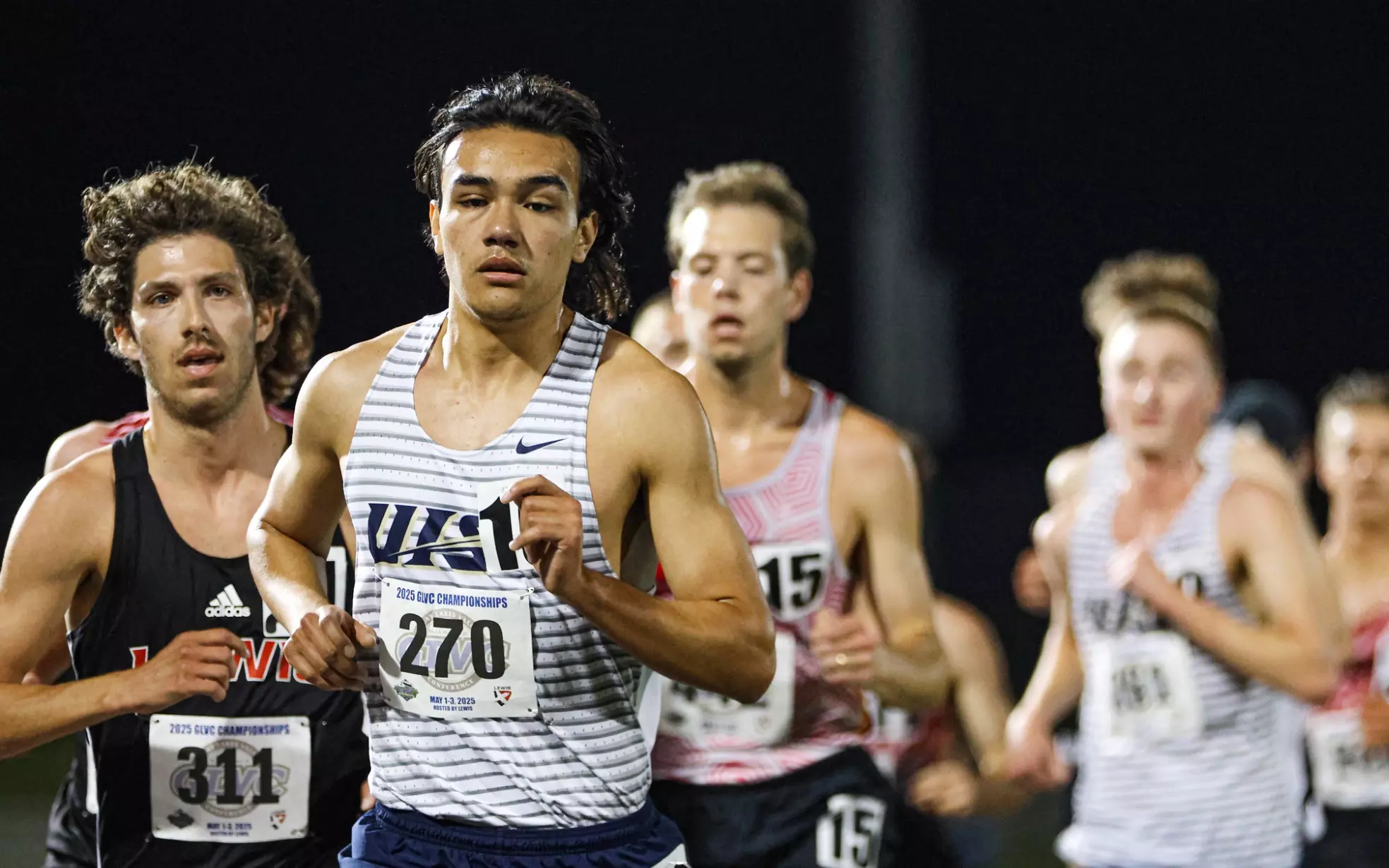 Matt Padilla running outdoor track in white UIS jersey