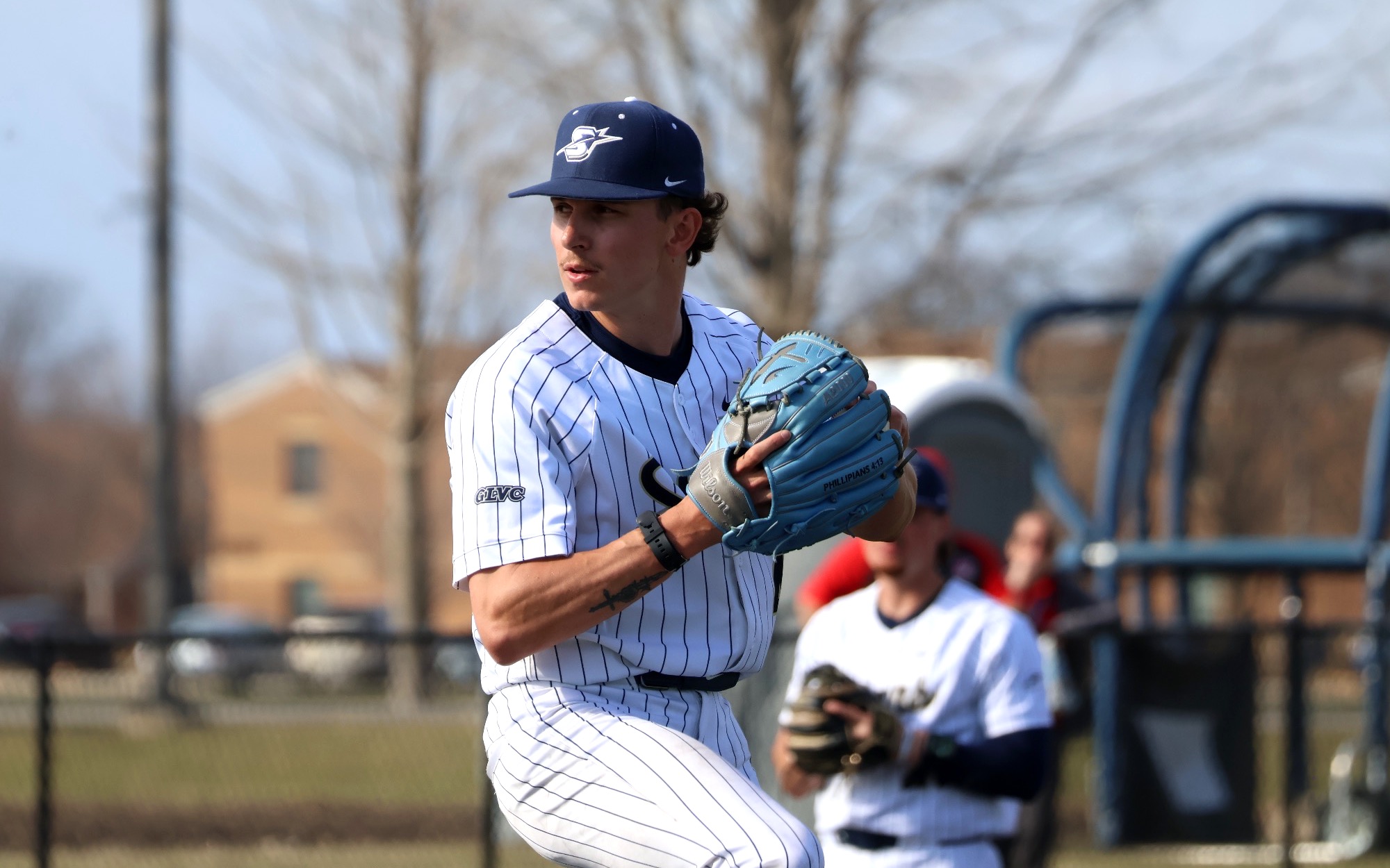 Jaden Mathon pitching in white UIS uniform
