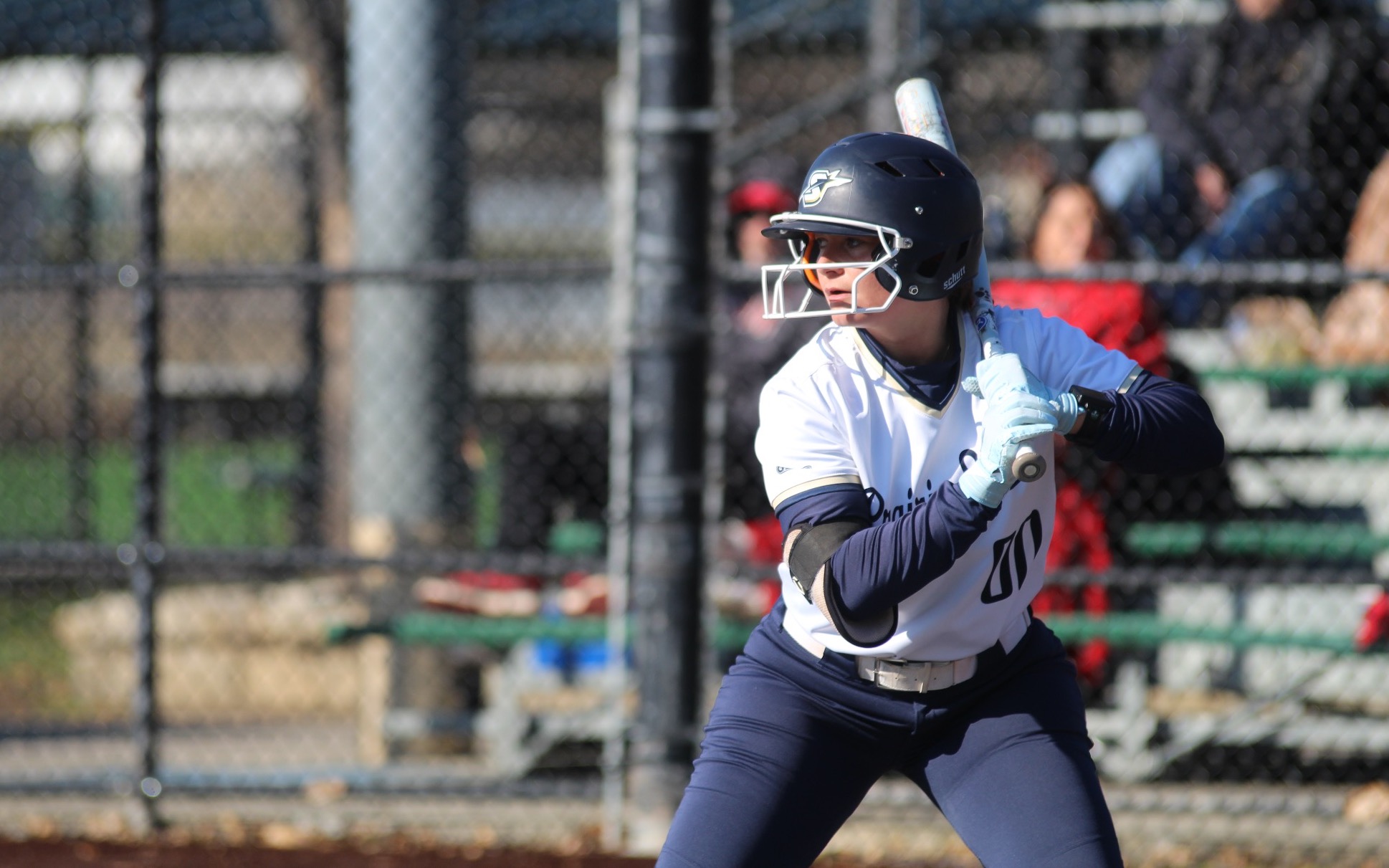 Olivia DeLuca batting in white UIS uniform