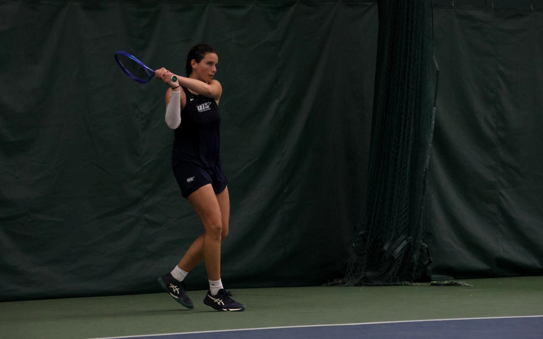 Ema Norma Bordean playing tennis in blue UIS uniform