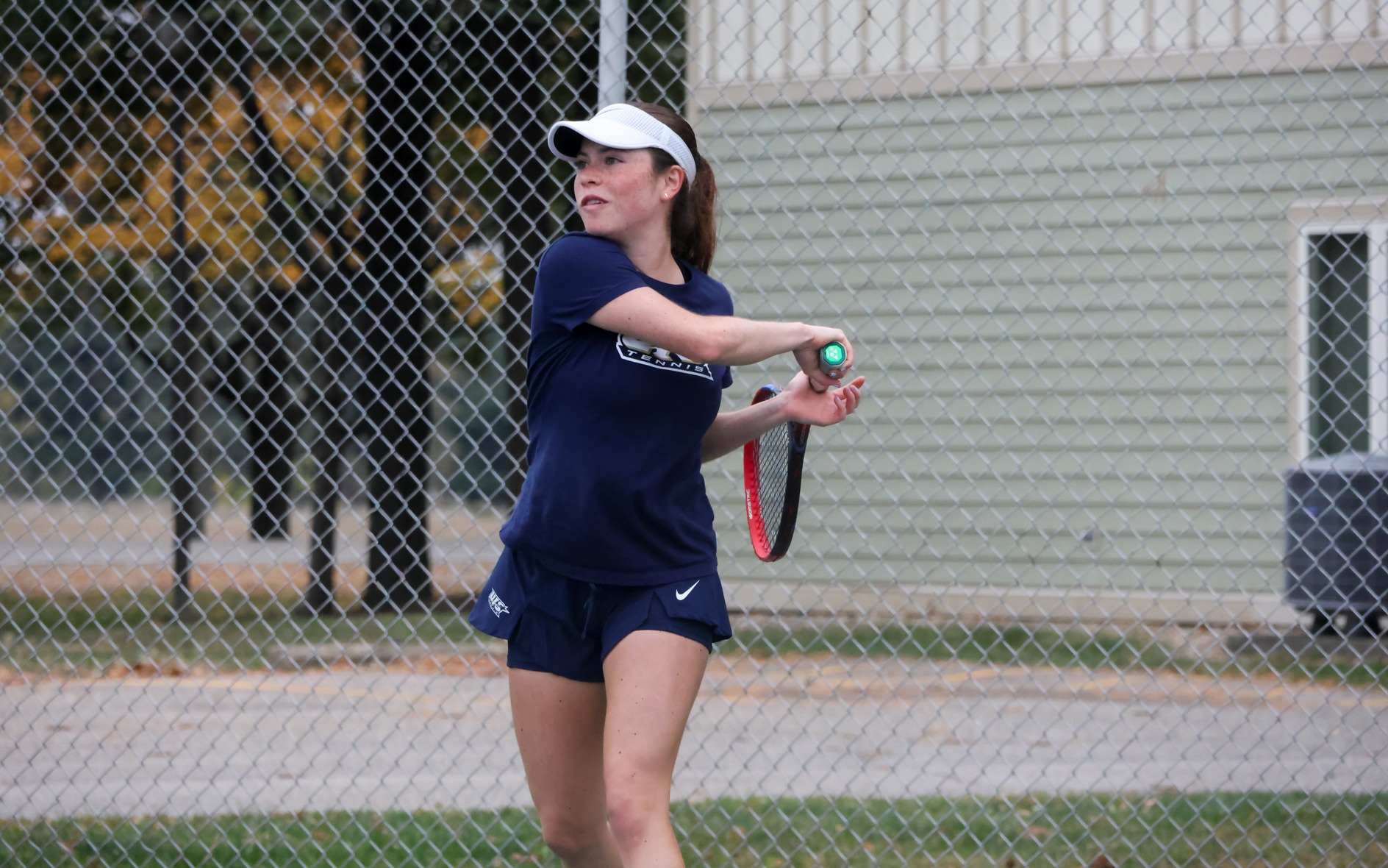 Maria Garcia Gama playing tennis in blue UIS uniform