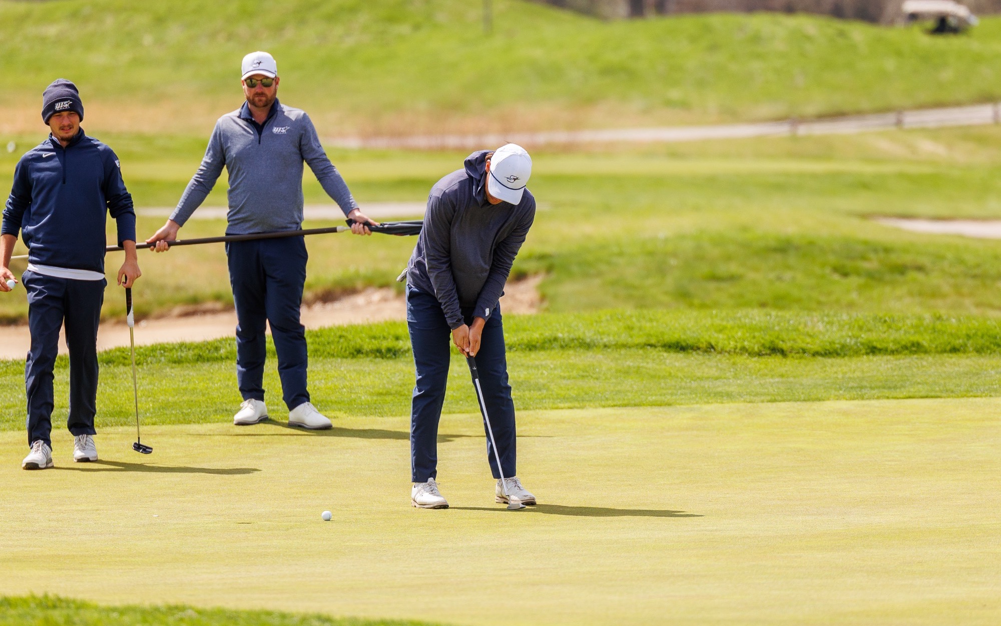 Julien Babineau golfing in gray and blue UIS gear