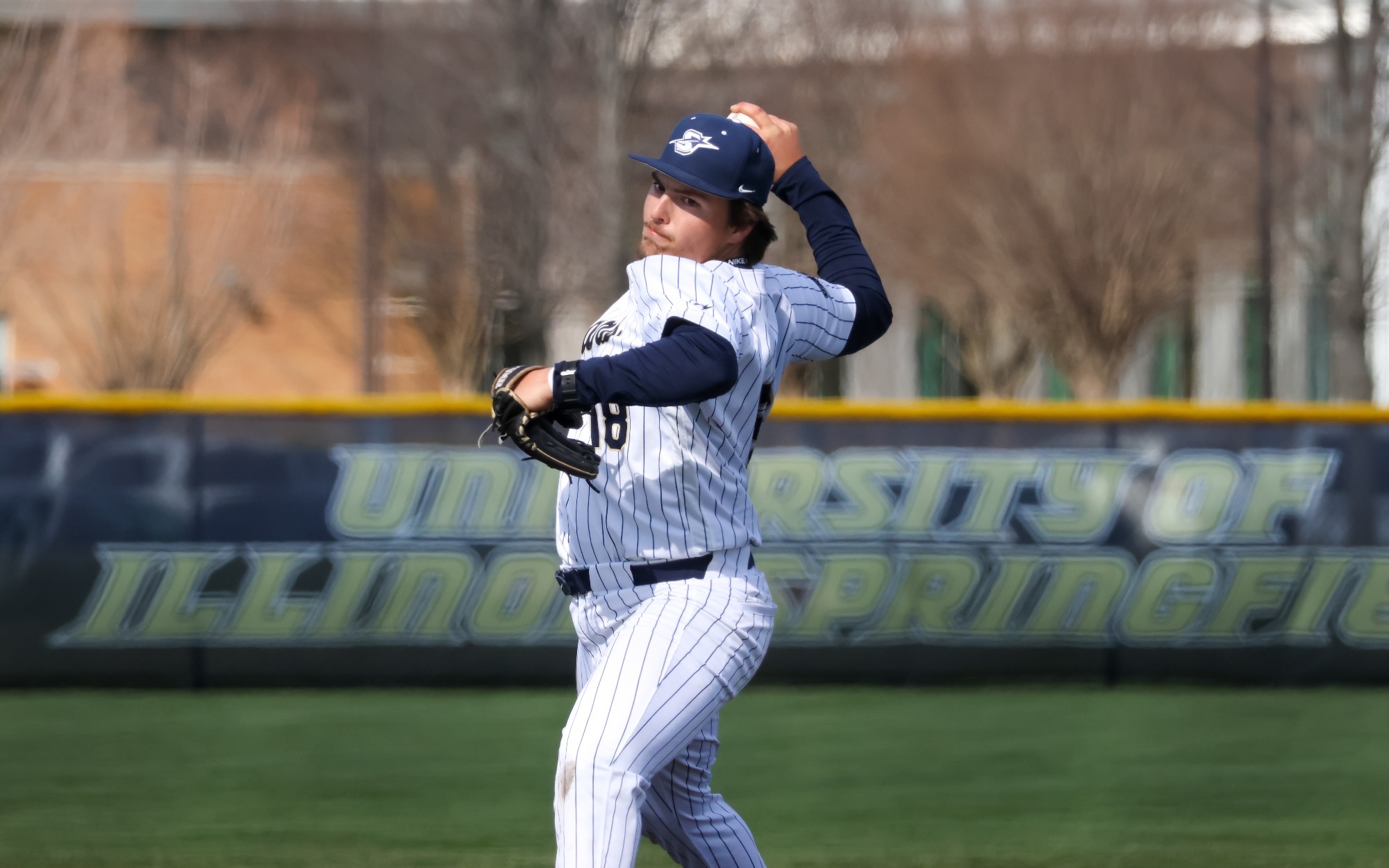 Isaac Graf pitching in white UIS baseball uniform
