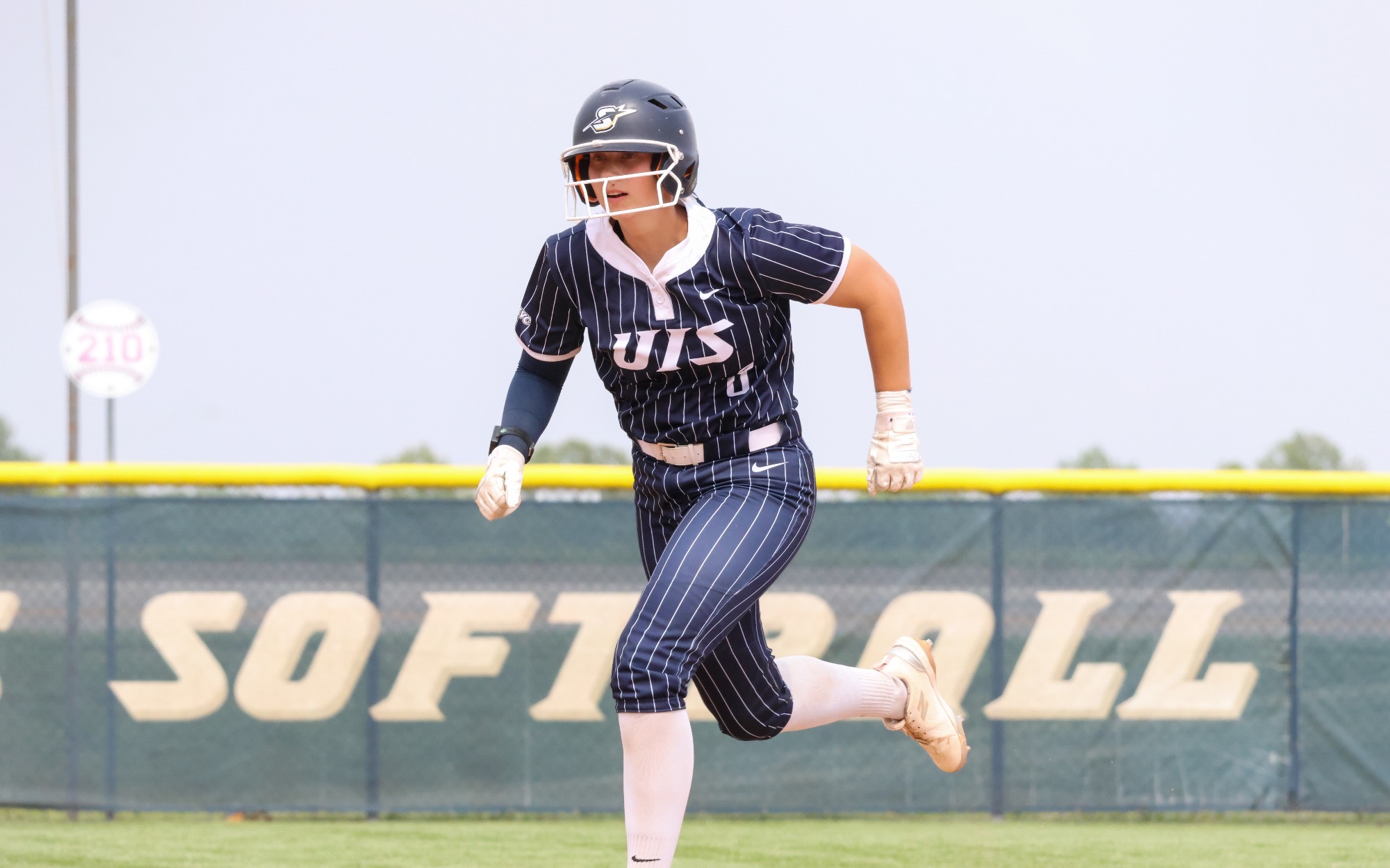 Rachel McMullen running the bases in blue UIS softball uniform