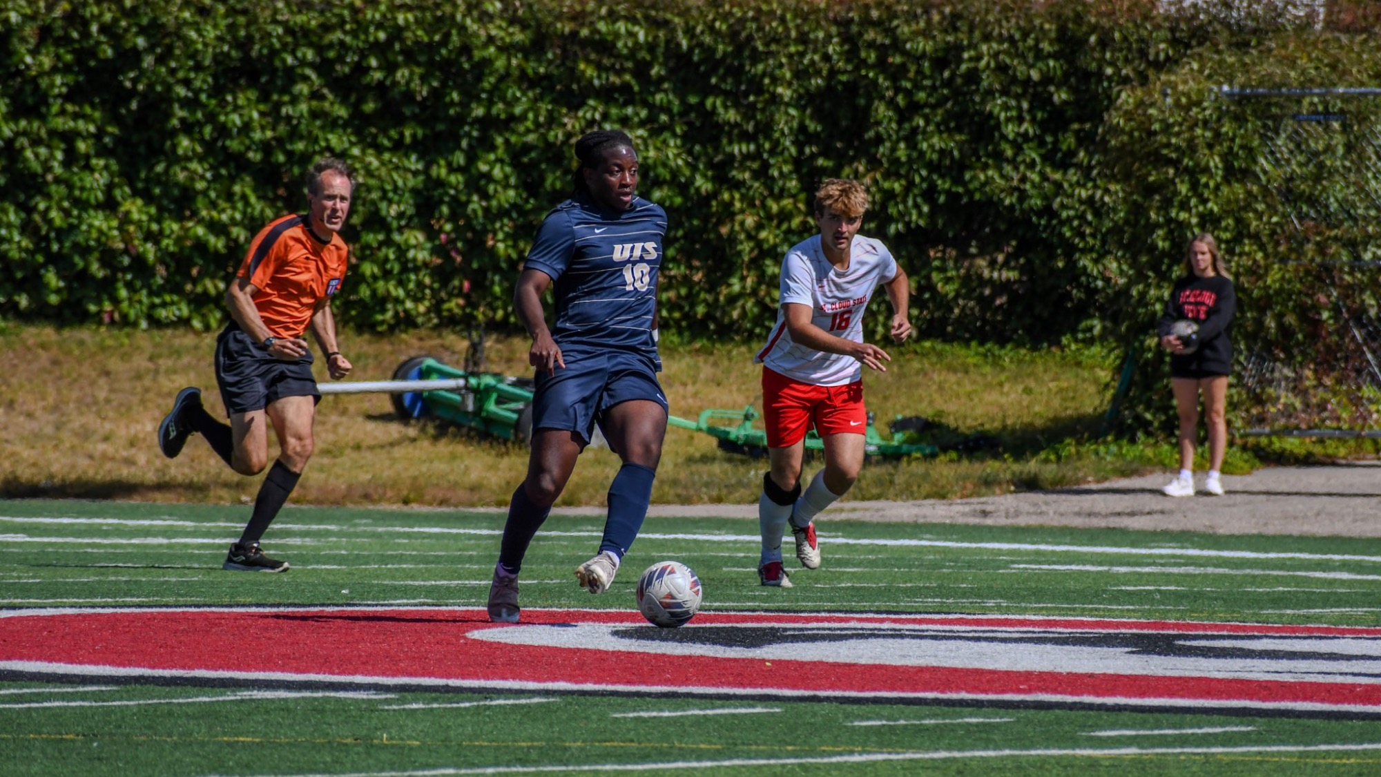 Nathan Oba-Okusanya playing soccer at away game in blue UIS uniform