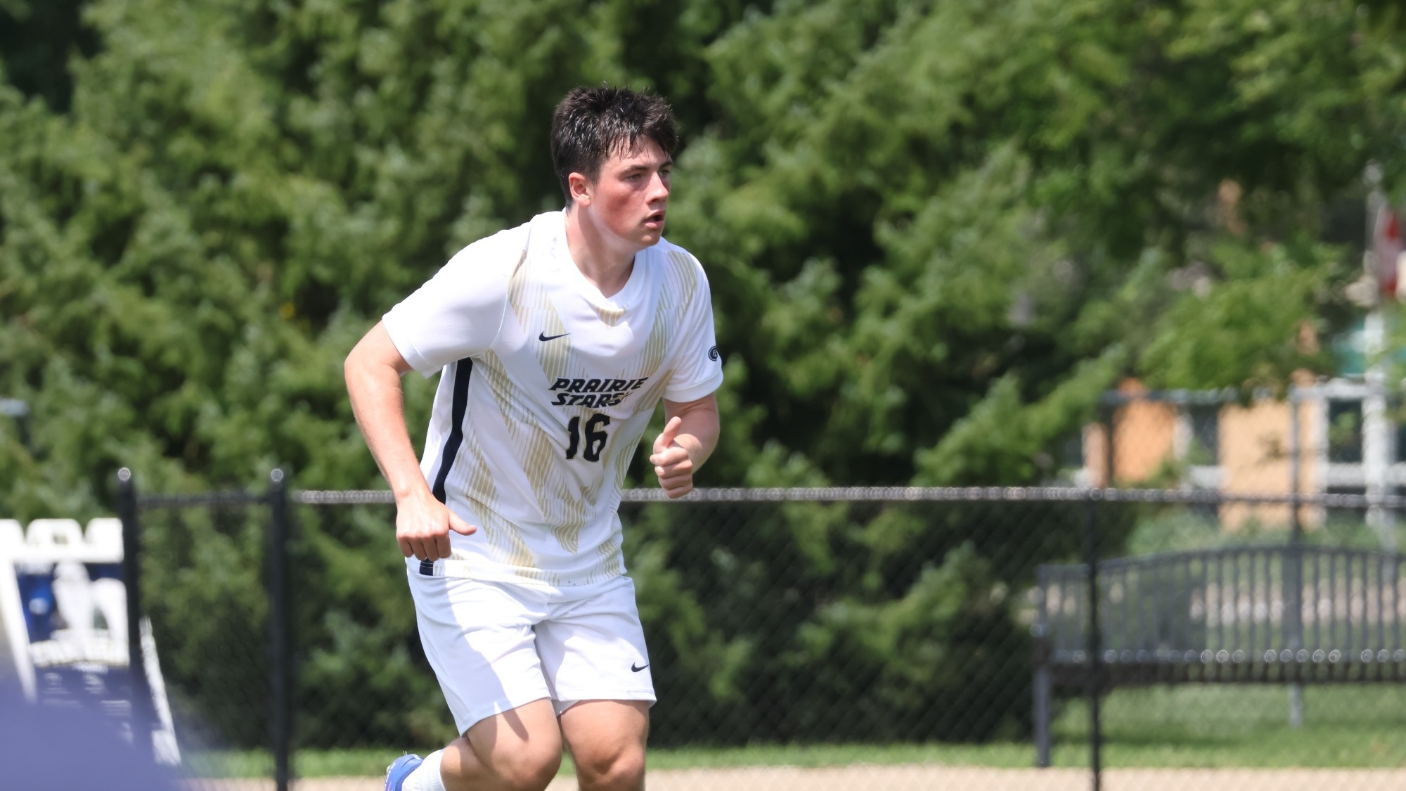 Jacob Shaw playing soccer in white UIS uniform