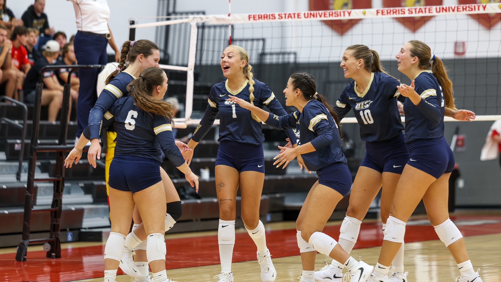 UIS Volleyball team celebrating on court at Ferris State tournament