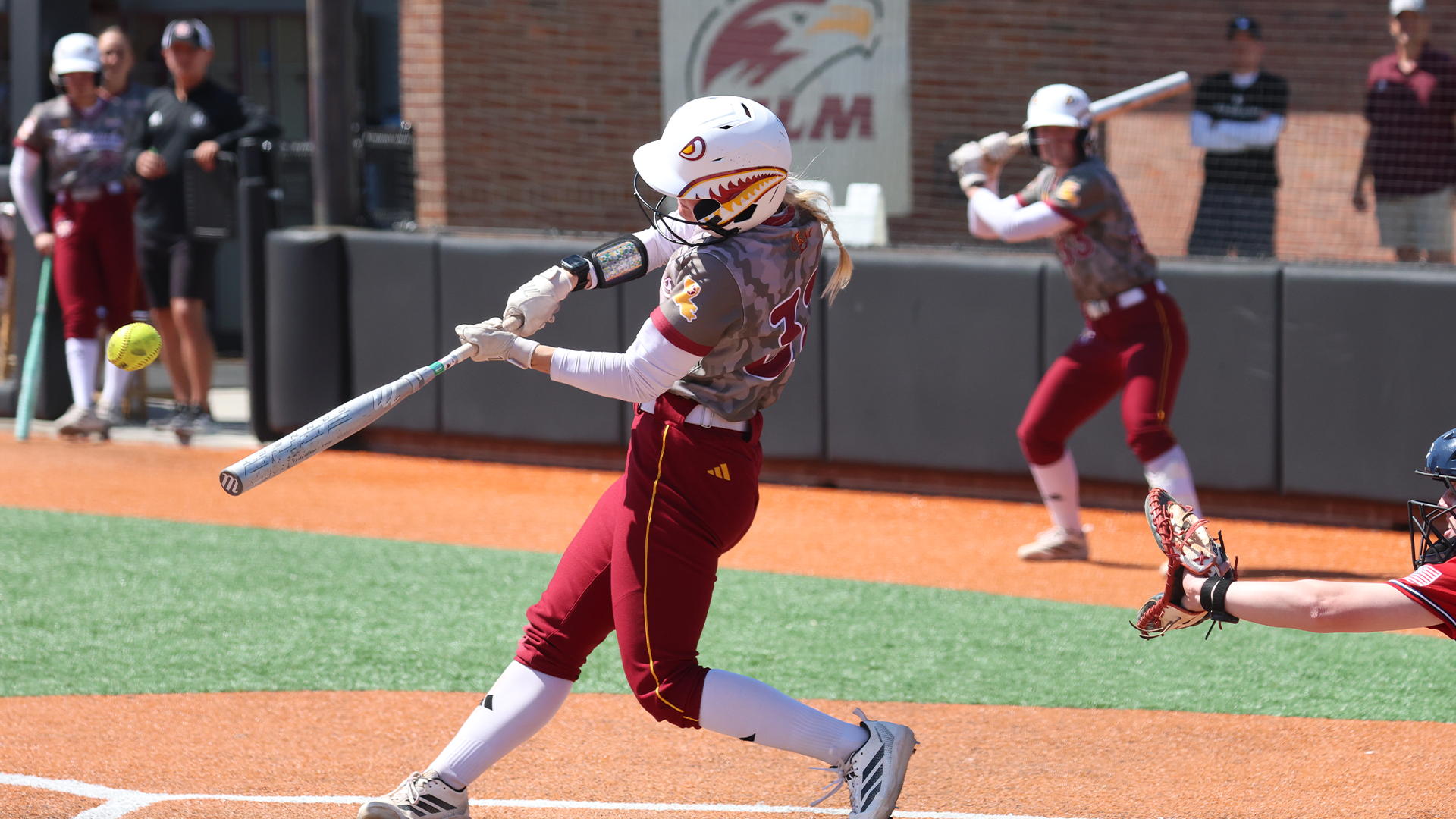 Meagan Brown hitting a ball in the ULM Softball Complex