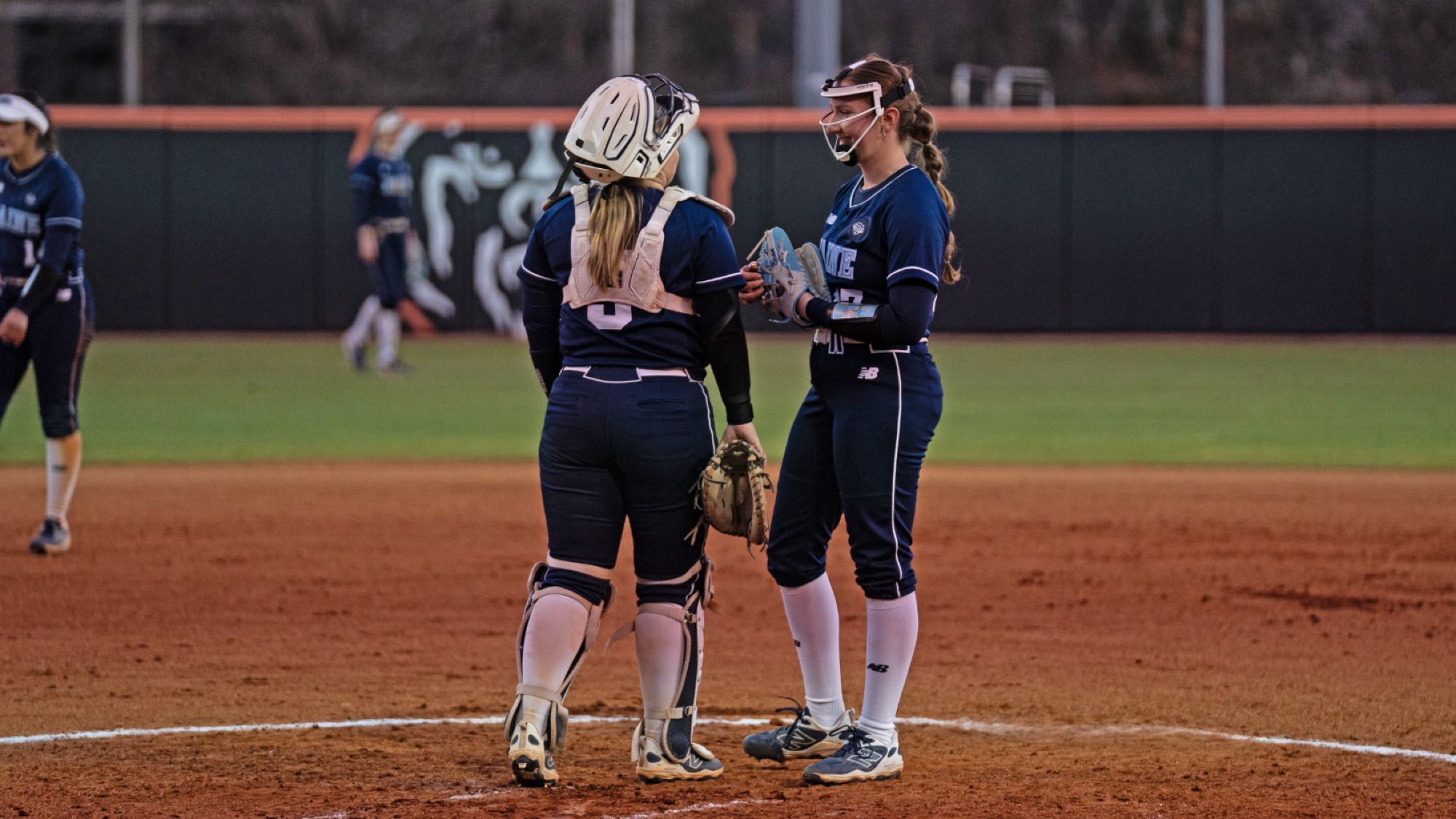 Hannah Hipwell and Morgan Pool talk in the pitching circle.