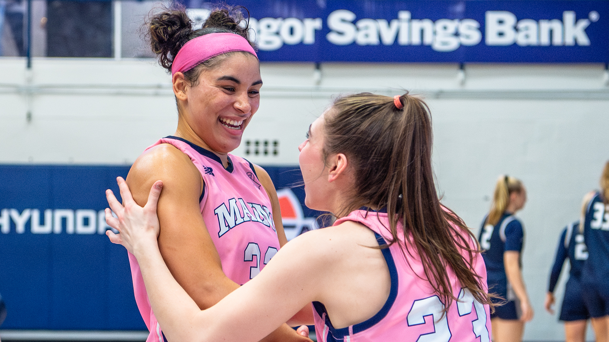 Adi Smith and Maddie Fitzpatrick celebrating in pink jerseys. 