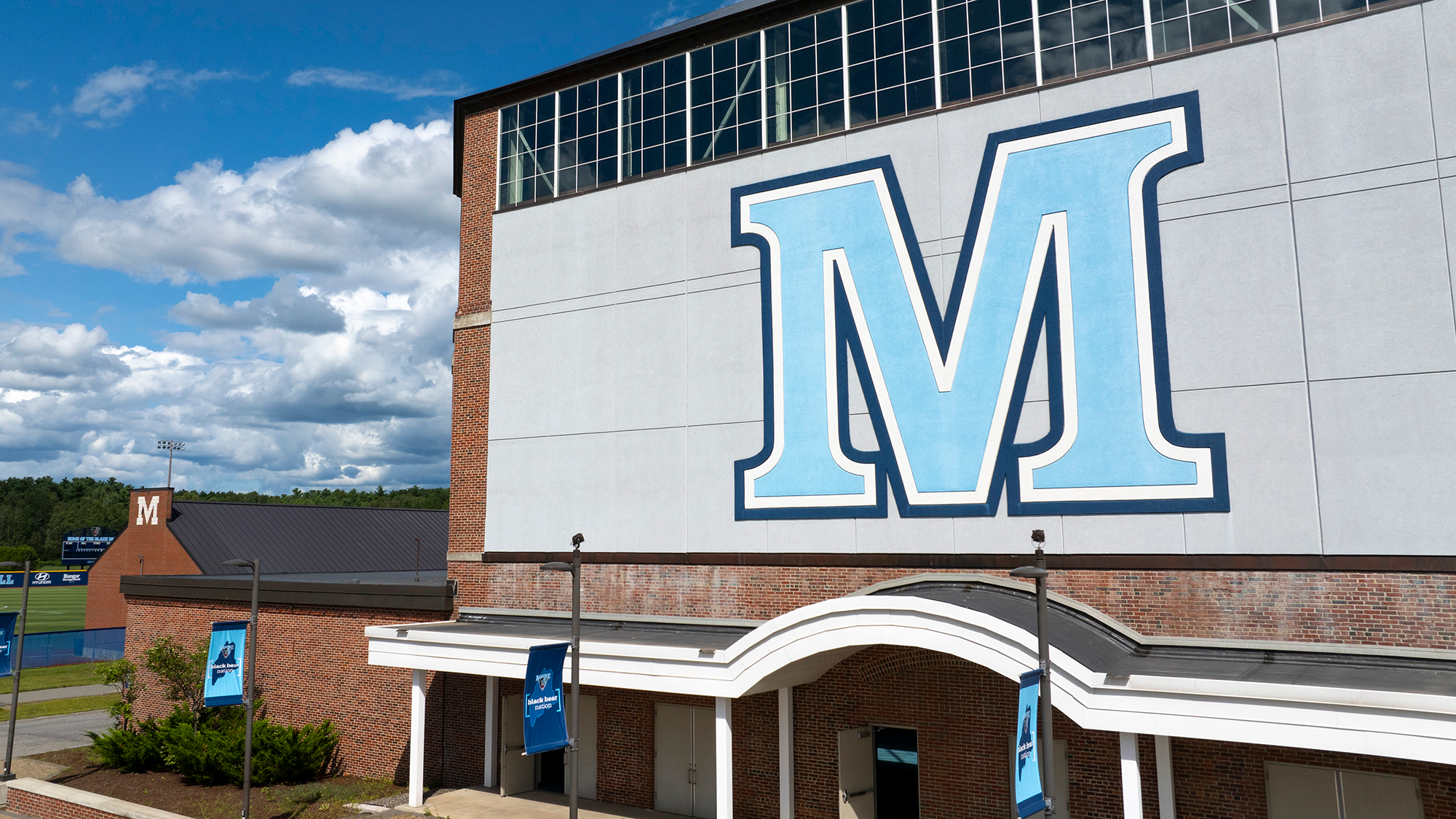 A photo of the front of the field house on a sunny day. 